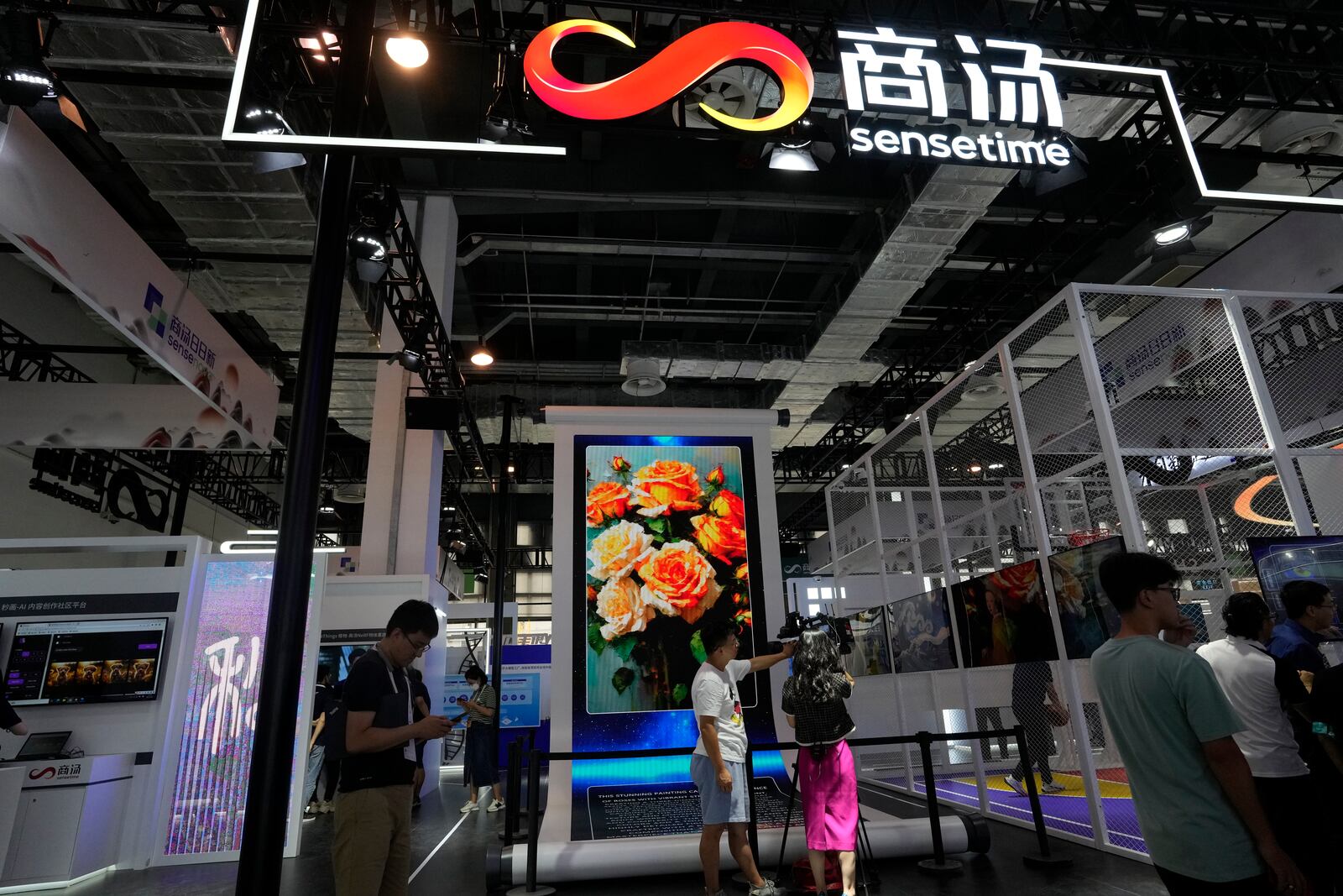 FILE - The booth for Chinese artificial intelligence company Sensetime demonstrates its AI generated images during the World AI Conference in Shanghai, July 5, 2023. (AP Photo/Ng Han Guan, File)