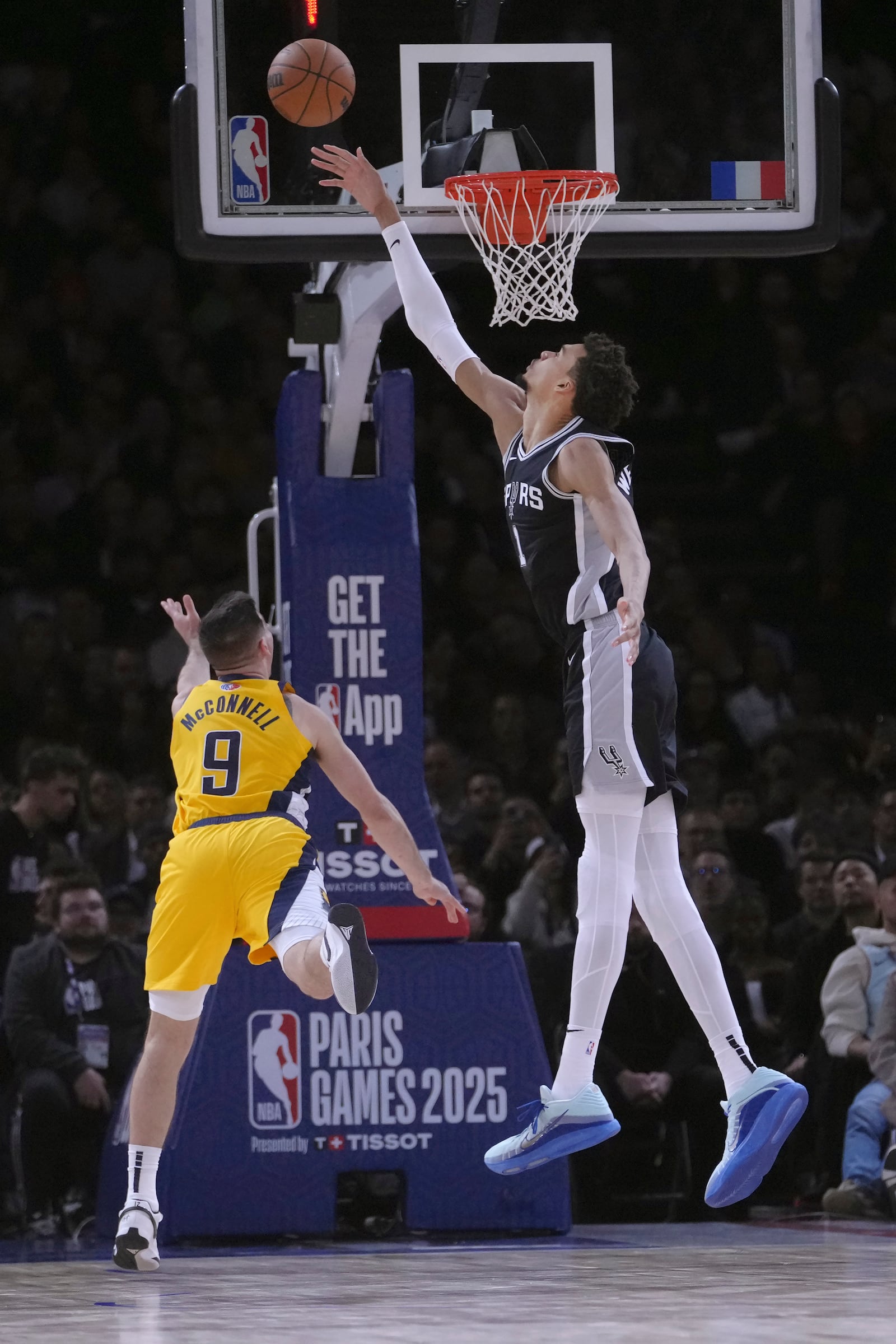 San Antonio Spurs center Victor Wembanyama, right, reaches for a shot by Indiana Pacers guard T.J. McConnell (9) during the second half of a Paris Games 2025 NBA basketball game in Paris, Thursday, Jan. 23, 2025. (AP Photo/Thibault Camus)