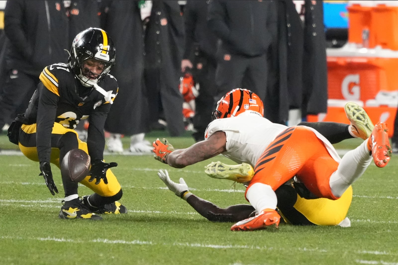 Pittsburgh Steelers cornerback Beanie Bishop Jr., left, intercepts a pass intended for Cincinnati Bengals wide receiver Ja'Marr Chase, top right, that was broken up by Steelers linebacker Patrick Queen, bottom right, during the first half of an NFL football game in Pittsburgh, Saturday, Jan. 4, 2025. (AP Photo/Gene J. Puskar)