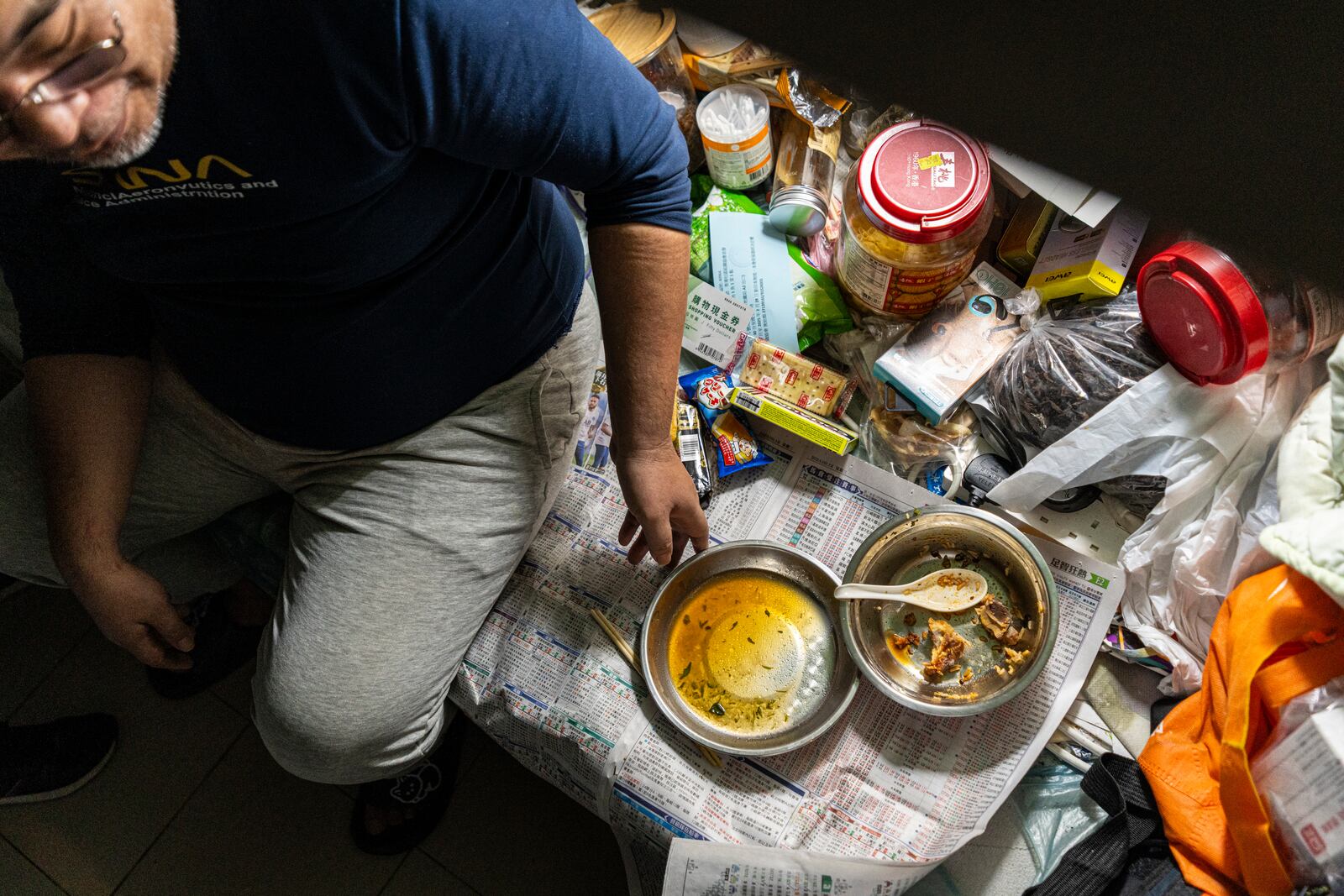 Resident Law Chung-yu has dinner in his bed space in Sham Shui Po district of Hong Kong, on Feb. 6, 2025. (AP Photo/Chan Long Hei)