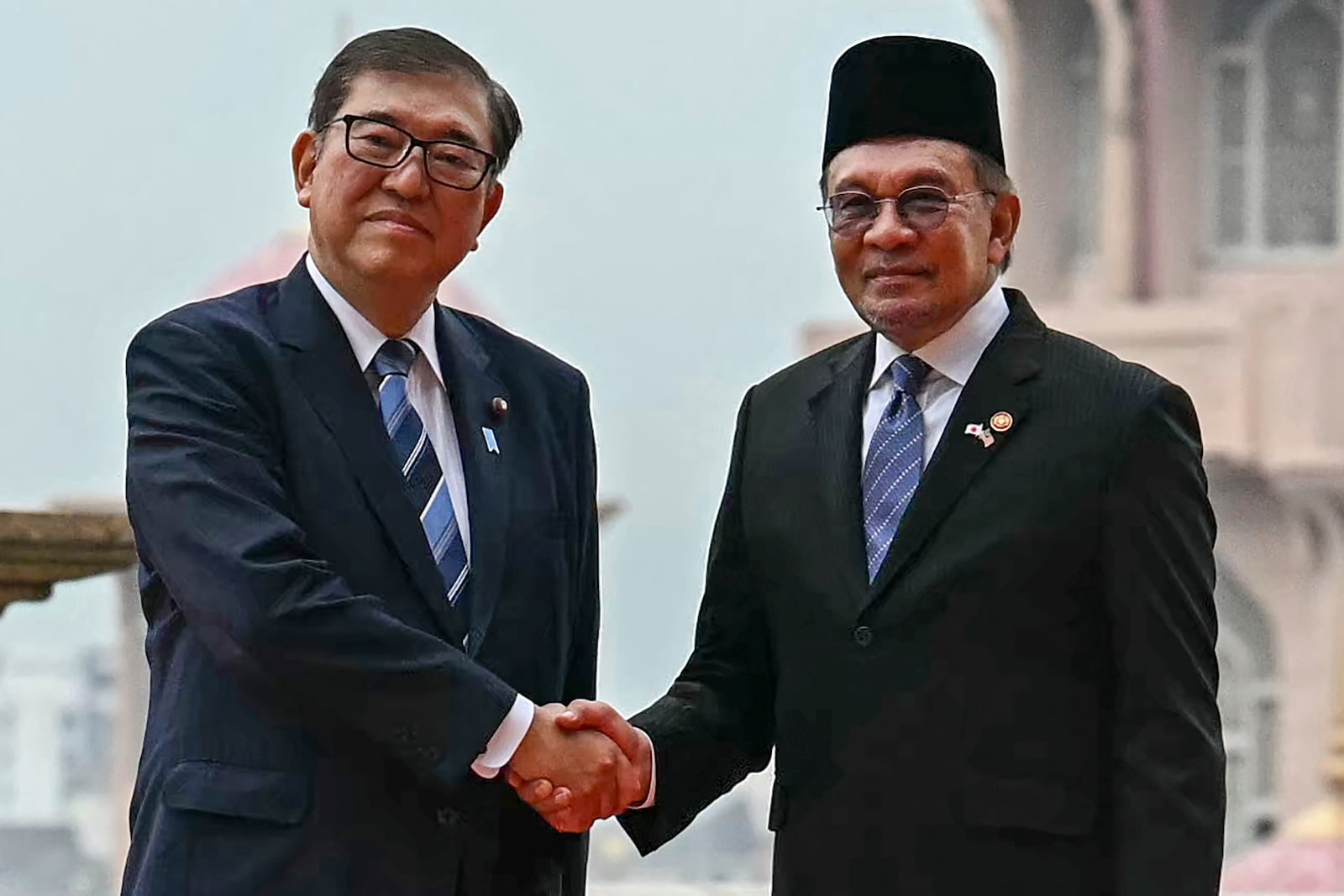 Malaysia's Prime Minister Anwar Ibrahim, right, and Japan's Prime Minister Shigeru Ishiba shake hands before a meeting in Putrajaya, Malaysia, Friday, Jan. 10, 2025. (Mohd Rasfan/Pool Photo via AP)