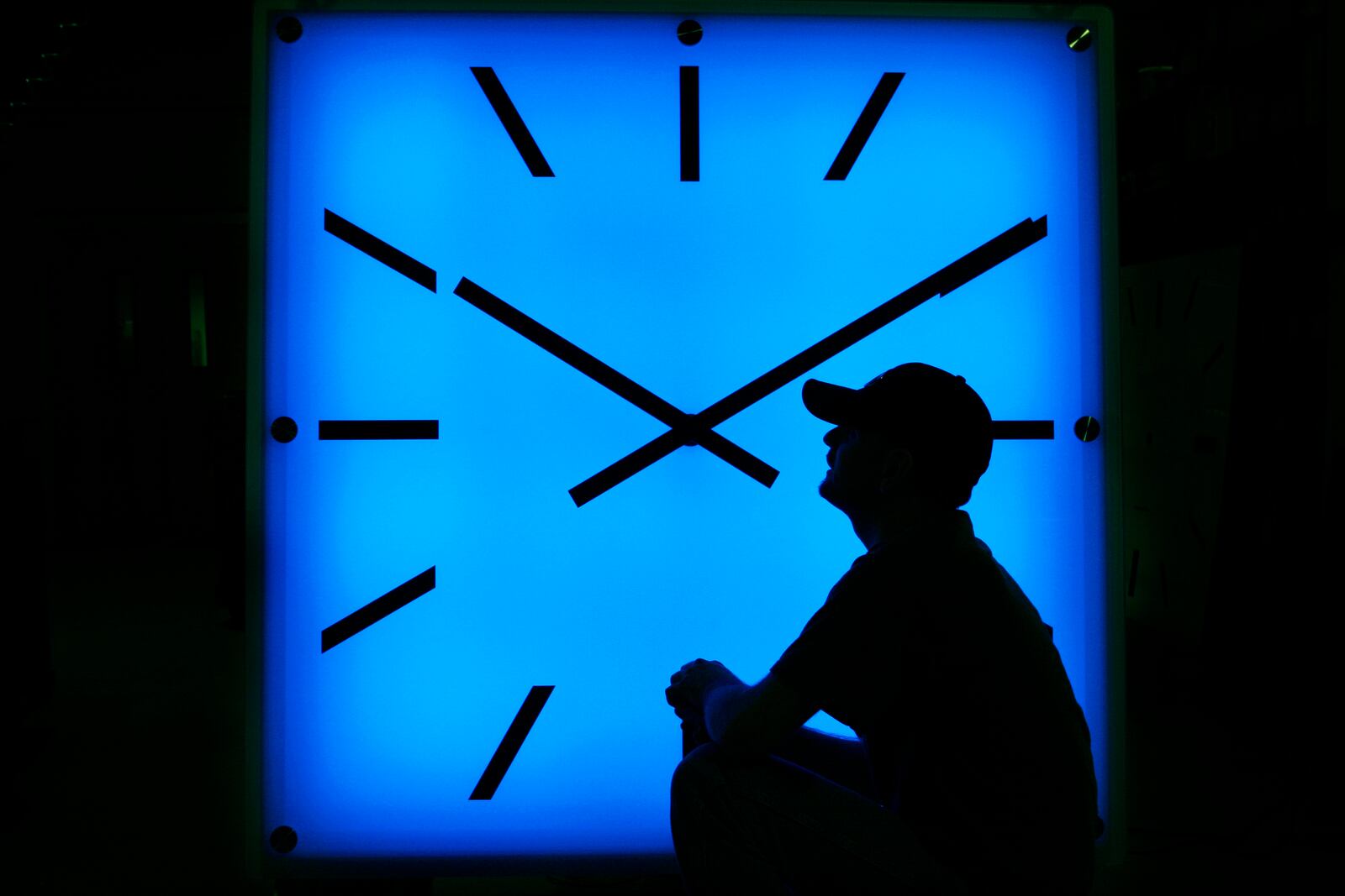 FILE - In this Oct. 30, 2008, file photo, an Electric Time Company employee adjusts the color on a clock at the plant in Medfield, Mass., days before the switch to standard time. (AP Photo/Elise Amendola, File)