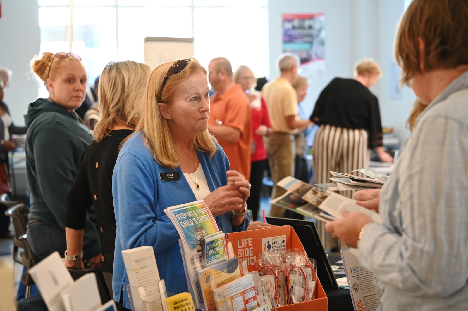 Last week, on Tuesday, Oct. 22, 2024, multiple local and state agencies hosted a Butler County Community Conversation that addressed the rise of suicide in Butler County, spread awareness and share resources as they provided ideas to inform the public. Pictured is Lynda O'Conner at the Envision Partnerships booth during a mini-expo highlighting resources at the Fitton Center in downtown Hamilton. MICHAEL D. PITMAN/STAFF