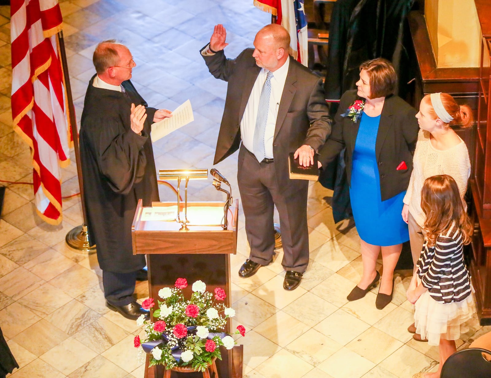 Greg Howard, accompanied by his wife Melynda Cook Howard, and daughters Allie Howard and Lorena Reich, is sworn in Feb. 17 as the new Butler County Common Pleas judge. GREG LYNCH / STAFF