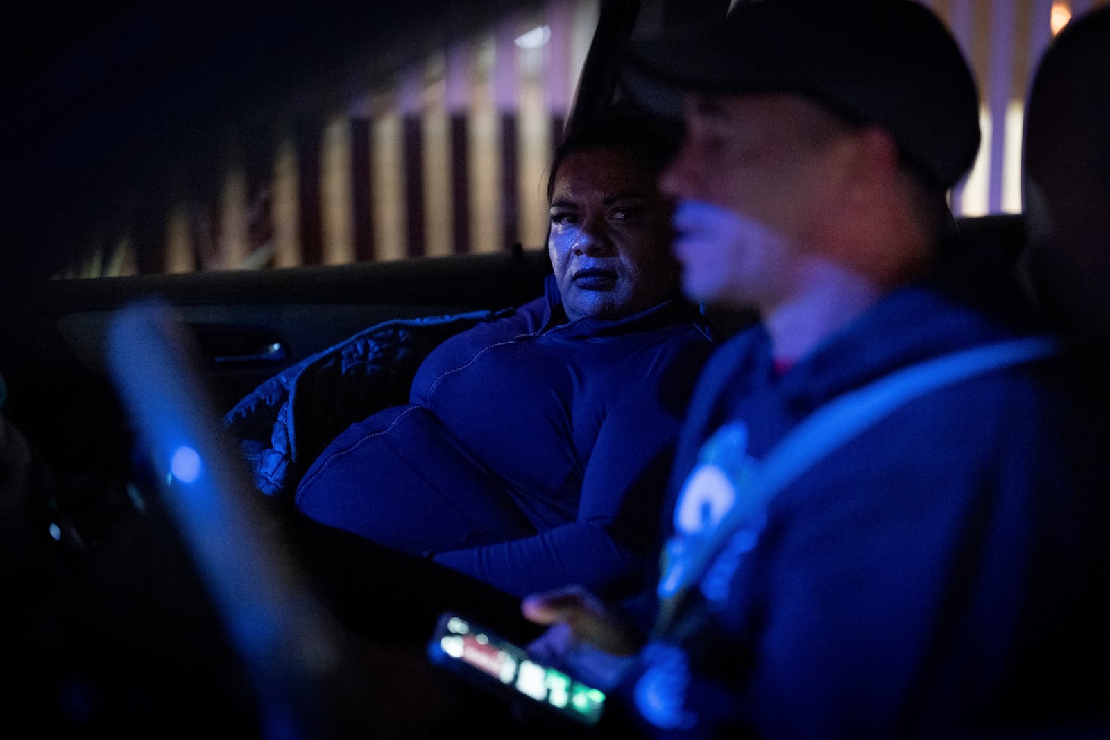 Martha Rosales, left, talks with Cuban migrant Yoandis Delgado as they drive to the Tijuana airport to pick up an arriving migrant who will stay at Rosales' home while waiting an appointment to apply for asylum in the United States through the CBP One app Wednesday, Aug. 28, 2024, in Tijuana, Mexico. (AP Photo/Gregory Bull)