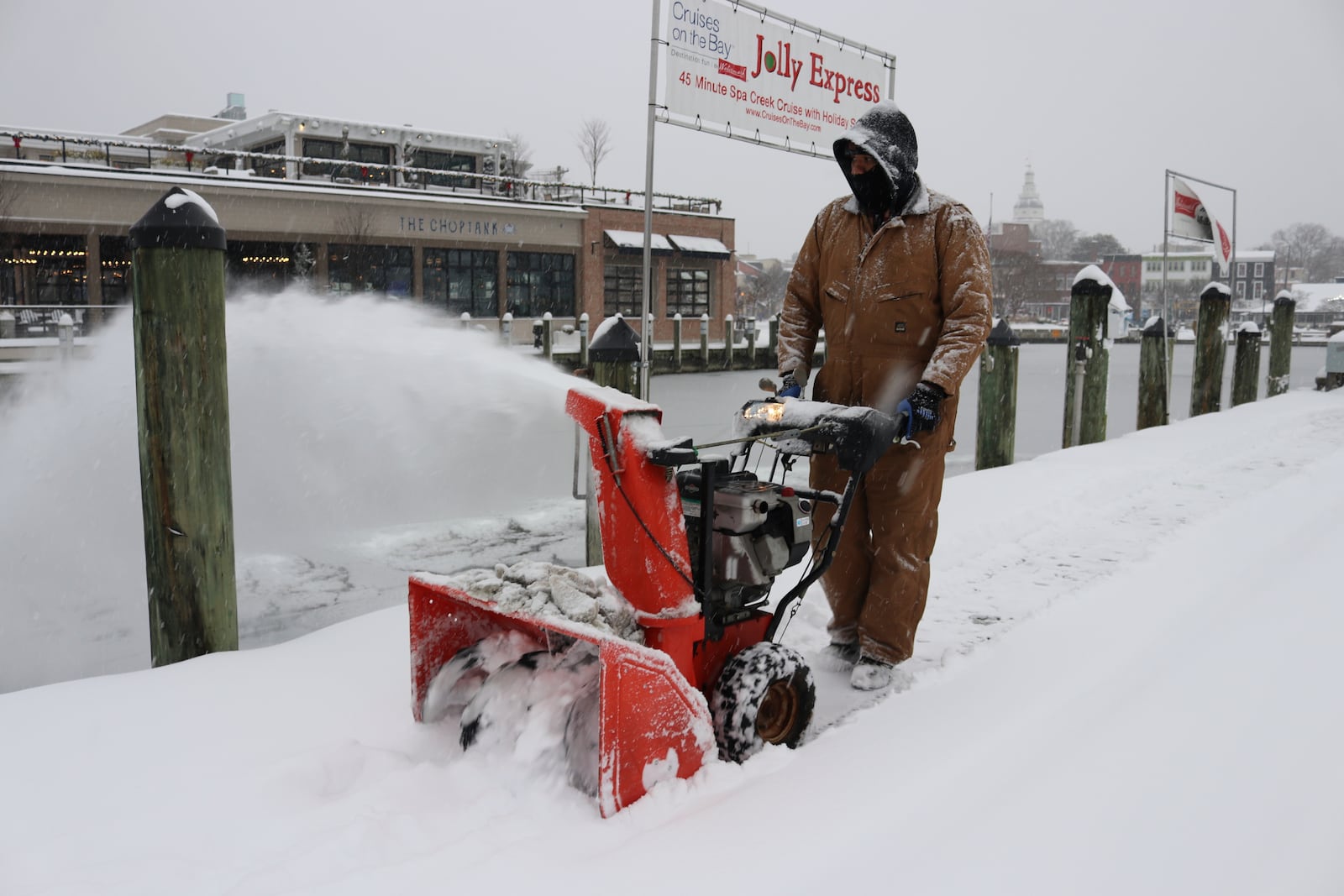 Tony Savage, who works for the city of Annapolis, clears snow along the City Dock in Annapolis, Md., Monday, Jan. 6, 2025. (AP Photo/Brian Witte)