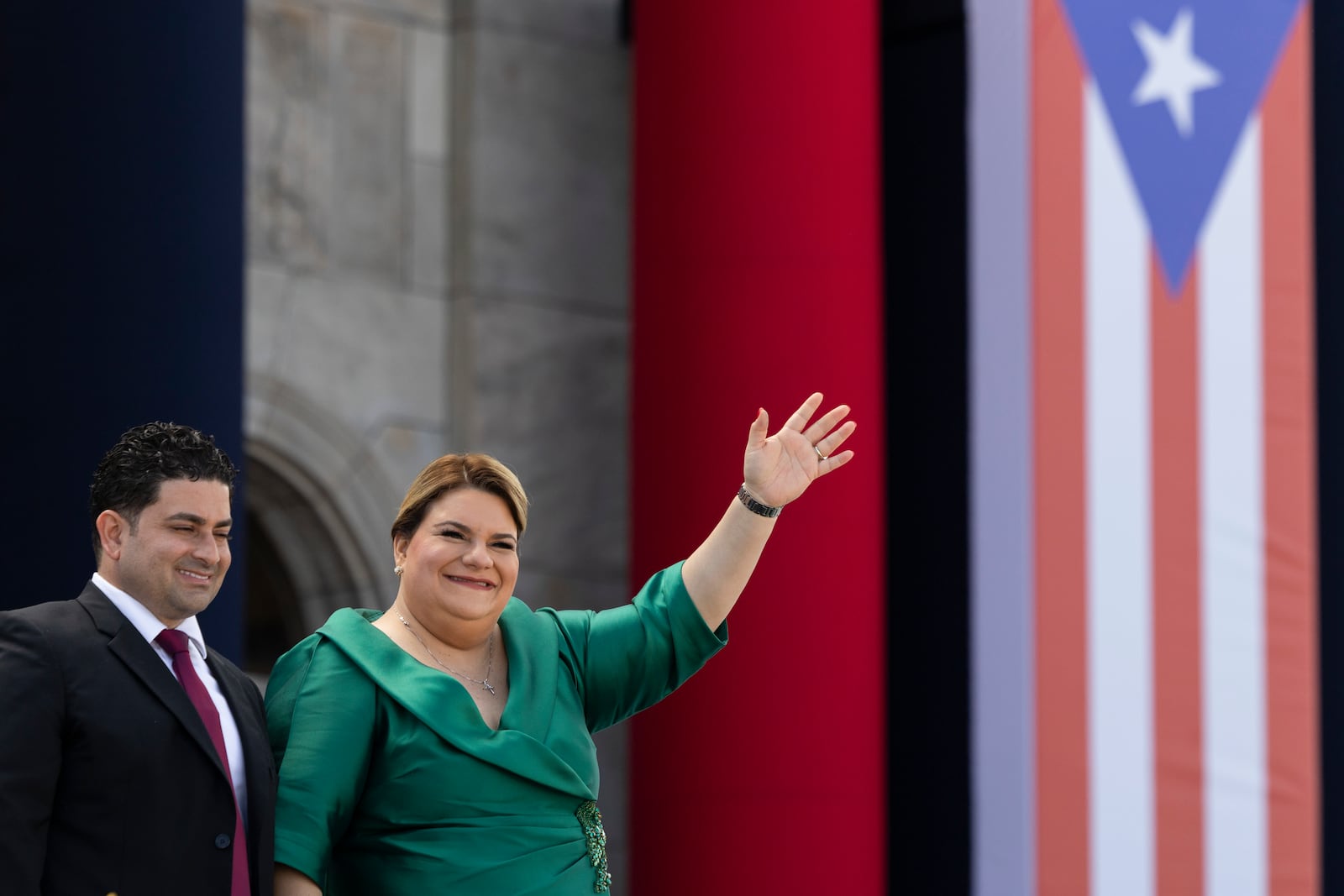 Jenniffer Gonzalez Colon waves alongside her husband during her swearing-in ceremony as governor outside the Capitol in San Juan, Puerto Rico, Thursday, Jan. 2, 2025. (AP Photo/Alejandro Granadillo)