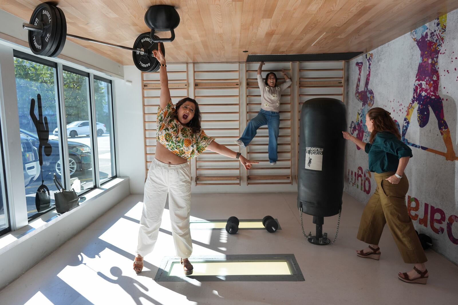 A group of friends pose for a picture that will be rotated upside down to create an optical illusion, at Paradox Museum Miami, Tuesday, Jan. 28, 2025, in Miami. (AP Photo/Rebecca Blackwell)