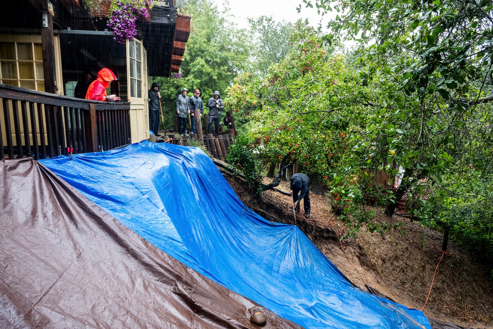 Residents work to shore up a mudslide as heavy rains fall near Healdsburg in unincorporated Sonoma County, Calif., Friday, Nov. 22, 2024. (AP Photo/Noah Berger)