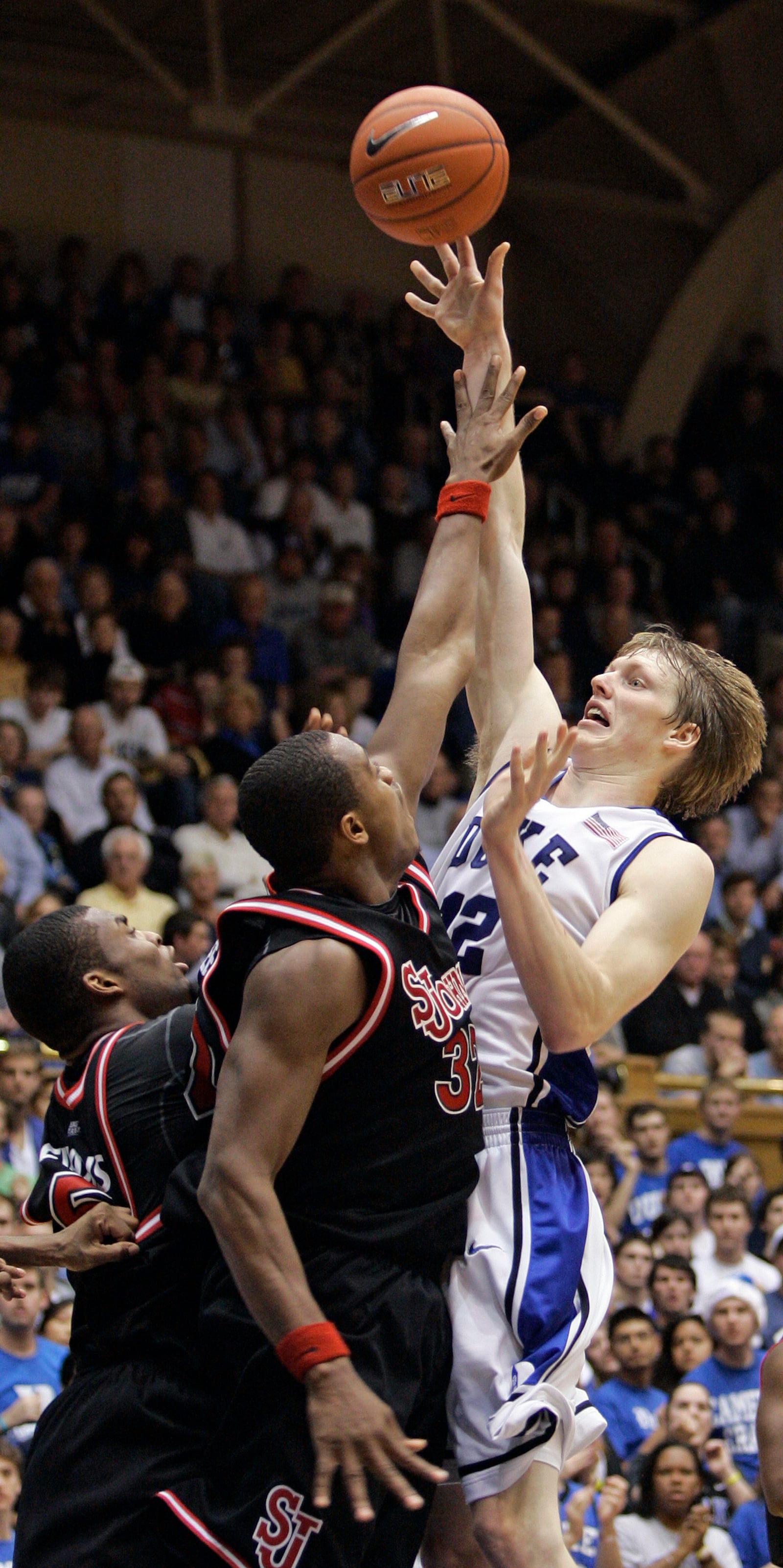 FILE - Duke's Kyle Singler, right, shoots as St. John's Justin Brownlee (32) and Sean Evans, left, defend during the second half of an NCAA college basketball game in Durham, N.C., Saturday, Dec. 5, 2009. (AP Photo/Gerry Broome, File)