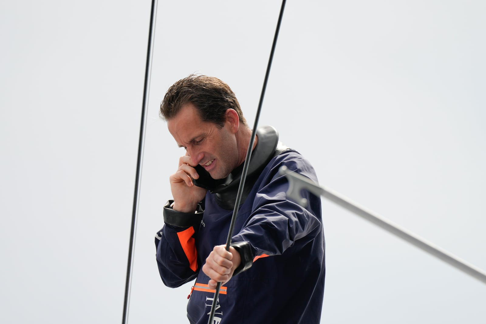 Ineos Britannia skipper Ben Ainslie talks on the phone before the Louis Vuitton 37th America's Cup race in Barcelona, Spain, Saturday, Oct. 12, 2024. (AP Photo/Bernat Armangue)