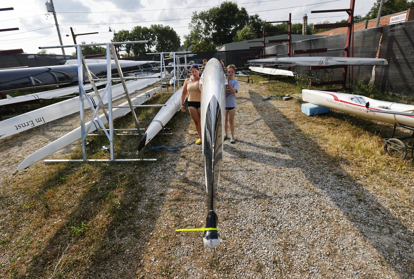 Great Miami Crew rowing team members get boats ready during practice Wednesday, Aug. 11, 2021 on the Great Miami River in Hamilton. NICK GRAHAM / STAFF