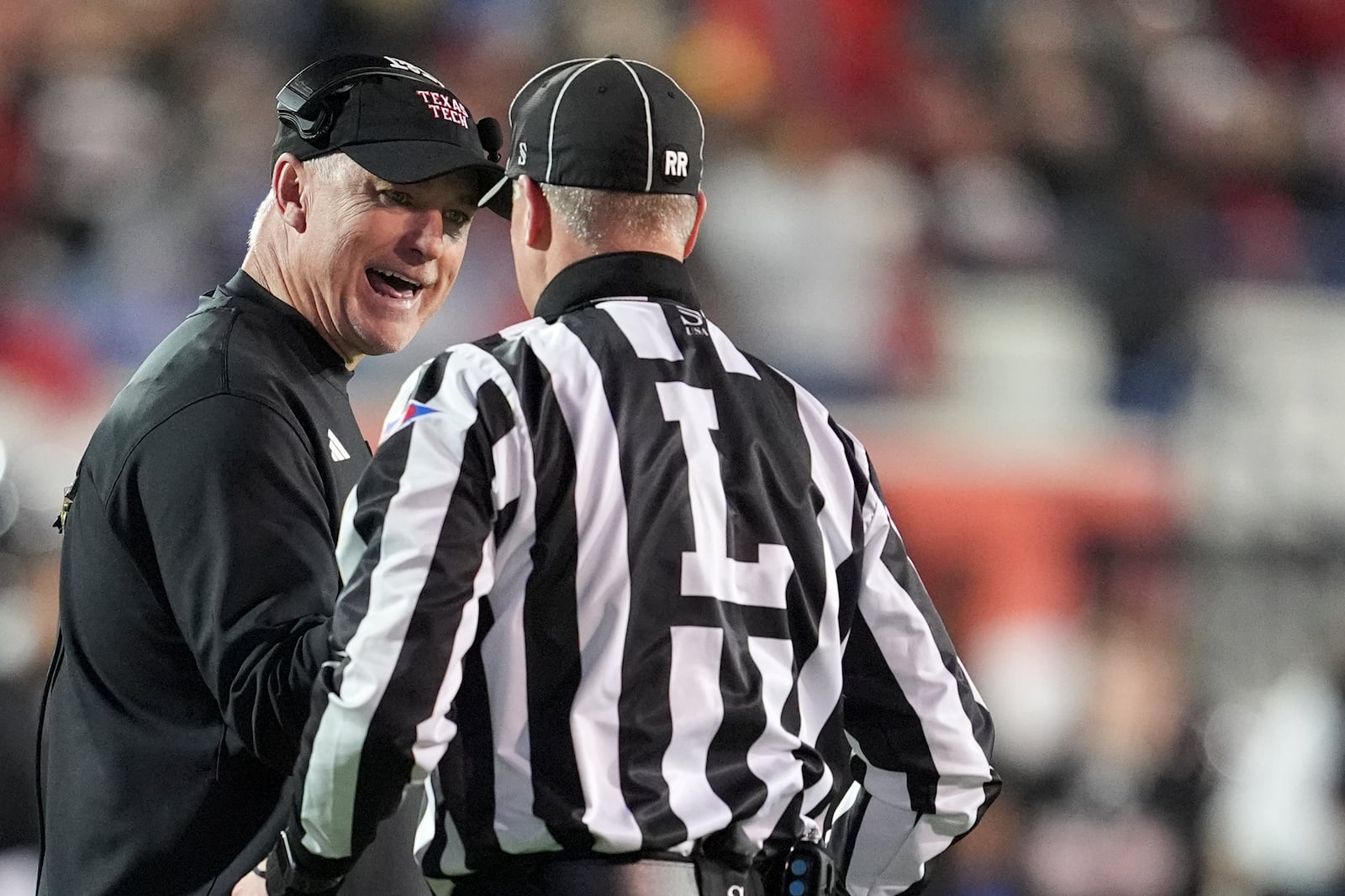 Texas Tech head coach Joey McGuire talks to an official during the first half of the Liberty Bowl NCAA college football game against Arkansas, Friday, Dec. 27, 2024, in Memphis, Tenn. (AP Photo/George Walker IV)