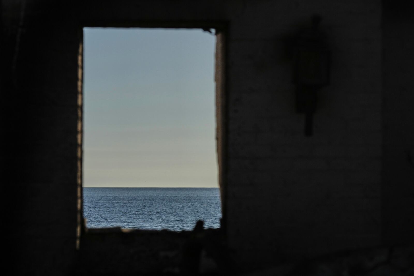 The Pacific Ocean is seen through the window of a home destroyed by the Palisades Fire, Thursday, Jan. 16, 2025, in Malibu, Calif. (AP Photo/Jae C. Hong)