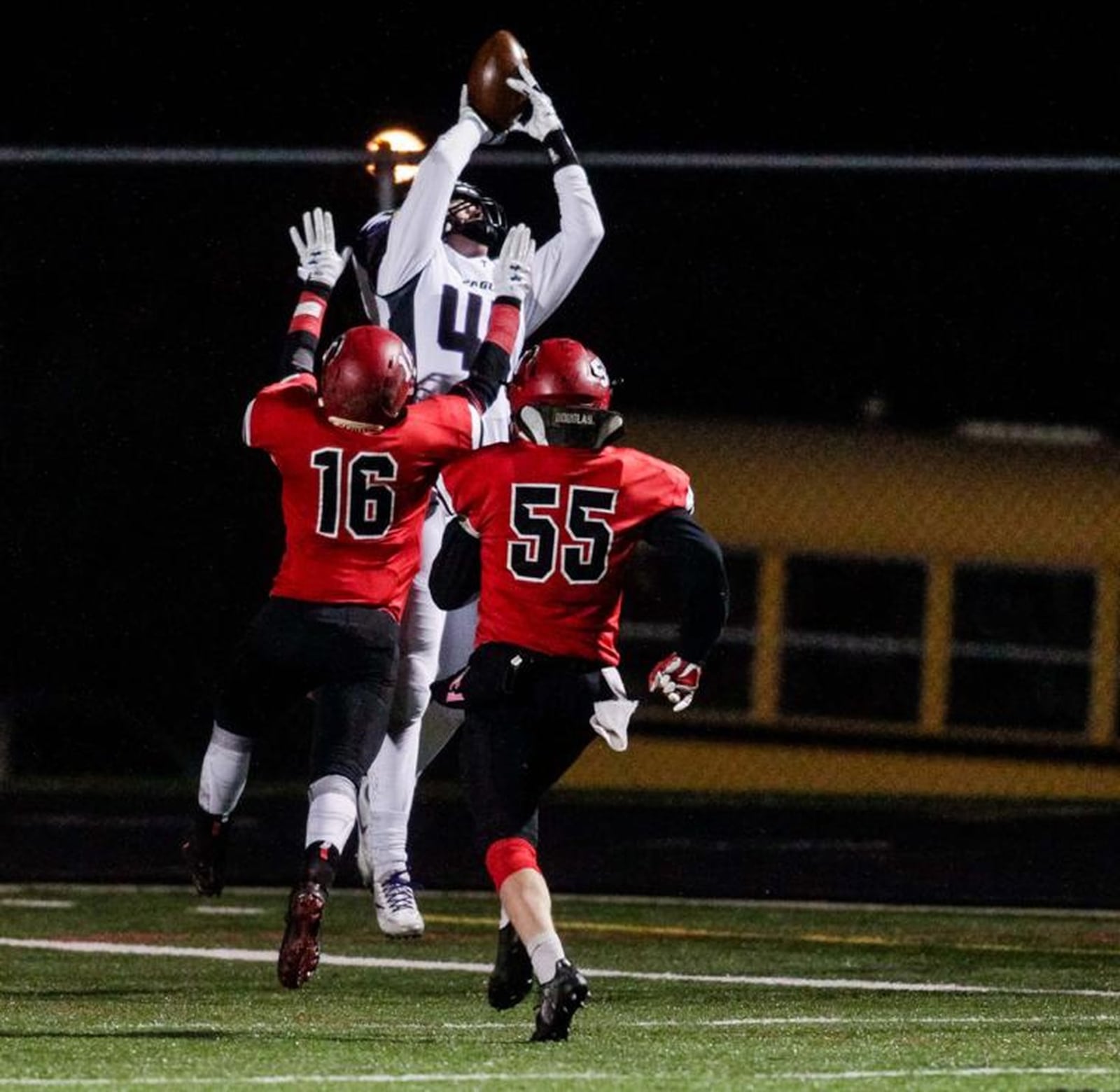 Cincinnati Hills Christian Academy’s Mason Bernhardt (44) catches a touchdown pass over Madison’s Tyler Baumgartner (16) and Levi Wilson (55) on Friday night during a Division V, Region 20 semifinal at Lakota East. NICK GRAHAM/STAFF