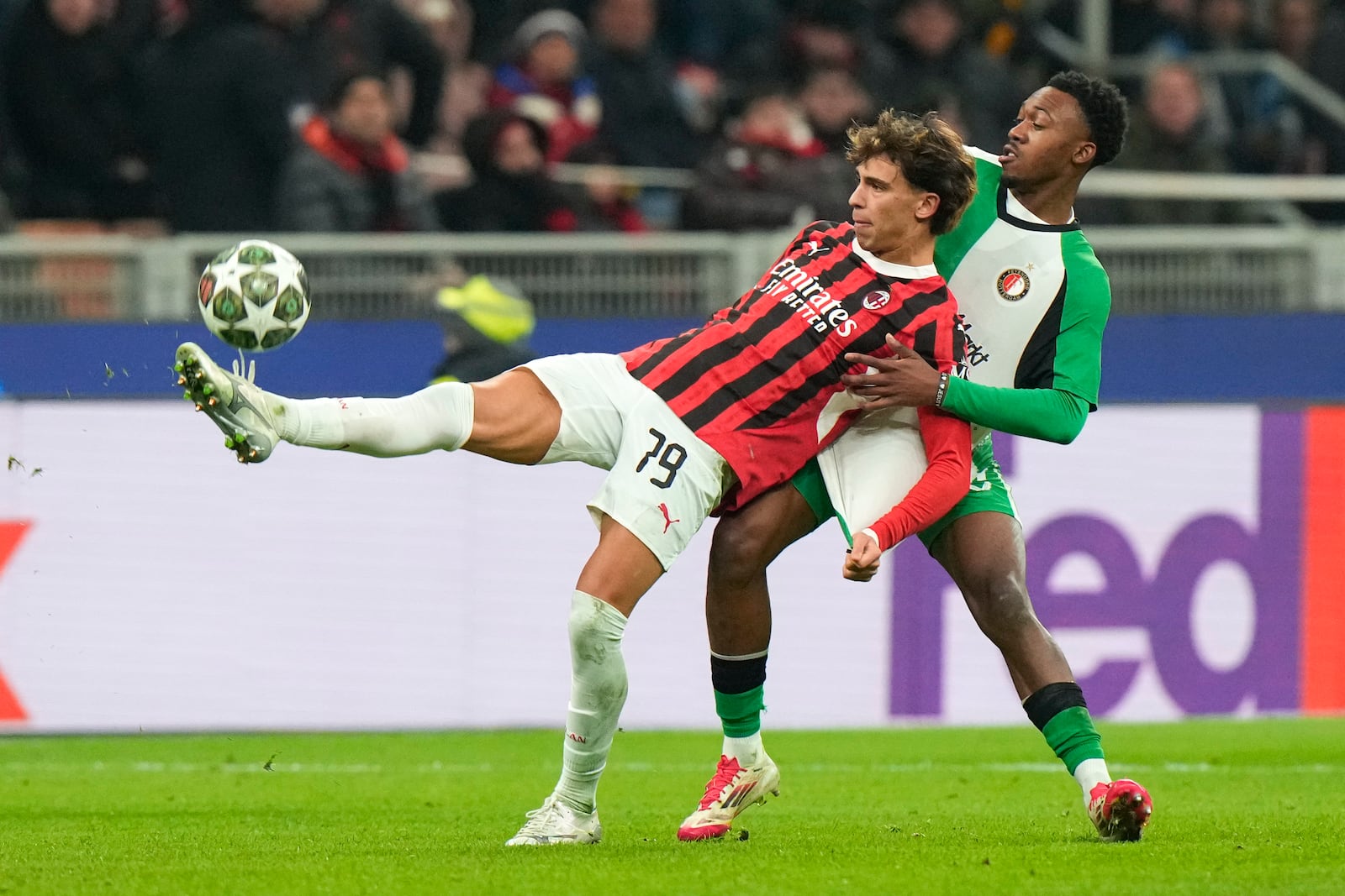 AC Milan's Joao Felix, left, challenges for the ball with Feyenoord's Antoni Milambo during Champions League, playoff second leg soccer match between AC Milan and Feyenoord, at the San Siro stadium in Milan, Italy, Tuesday, Feb.18, 2025. (AP Photo/Luca Bruno)