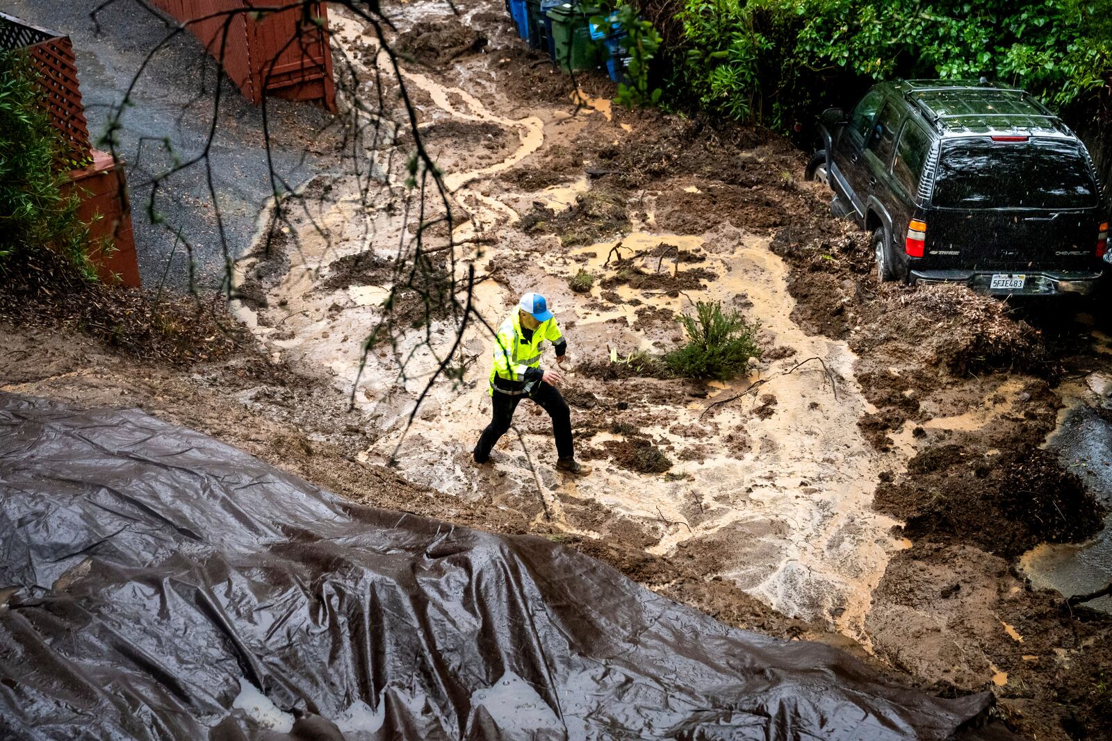 Permit Sonoma Director Tennis Wick crosses a mudslide to inspect a home as heavy rains fall near Healdsburg in unincorporated Sonoma County, Calif., Friday, Nov. 22, 2024. (AP Photo/Noah Berger)