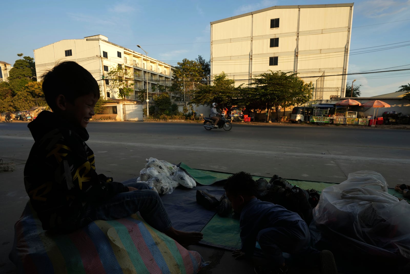 A boy plays near a building, where people trafficked under false pretenses are forced to work in online scams targeting people all over the world, in Phnom Penh, Cambodia, Sunday, Feb. 9, 2025. (AP Photo/Heng Sinith)