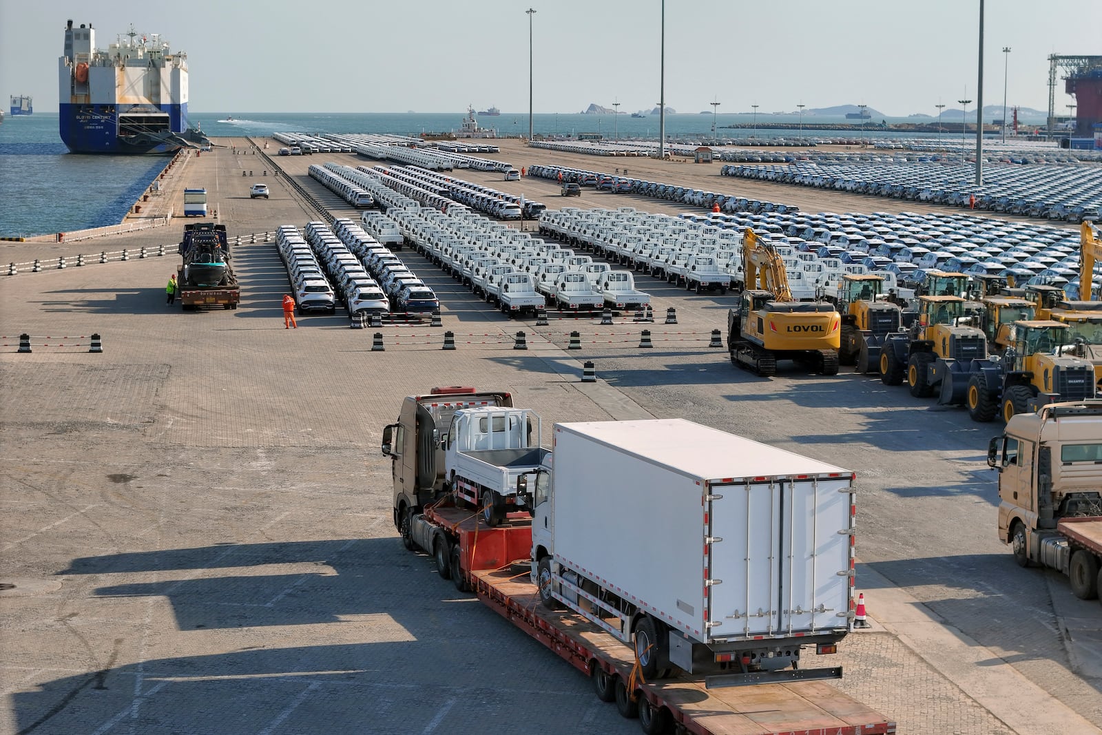 A truck loaded with vehicles moves to lines of vehicles for export at a port in Yantai in eastern China's Shandong province on Jan. 2, 2025. (Chinatopix via AP)