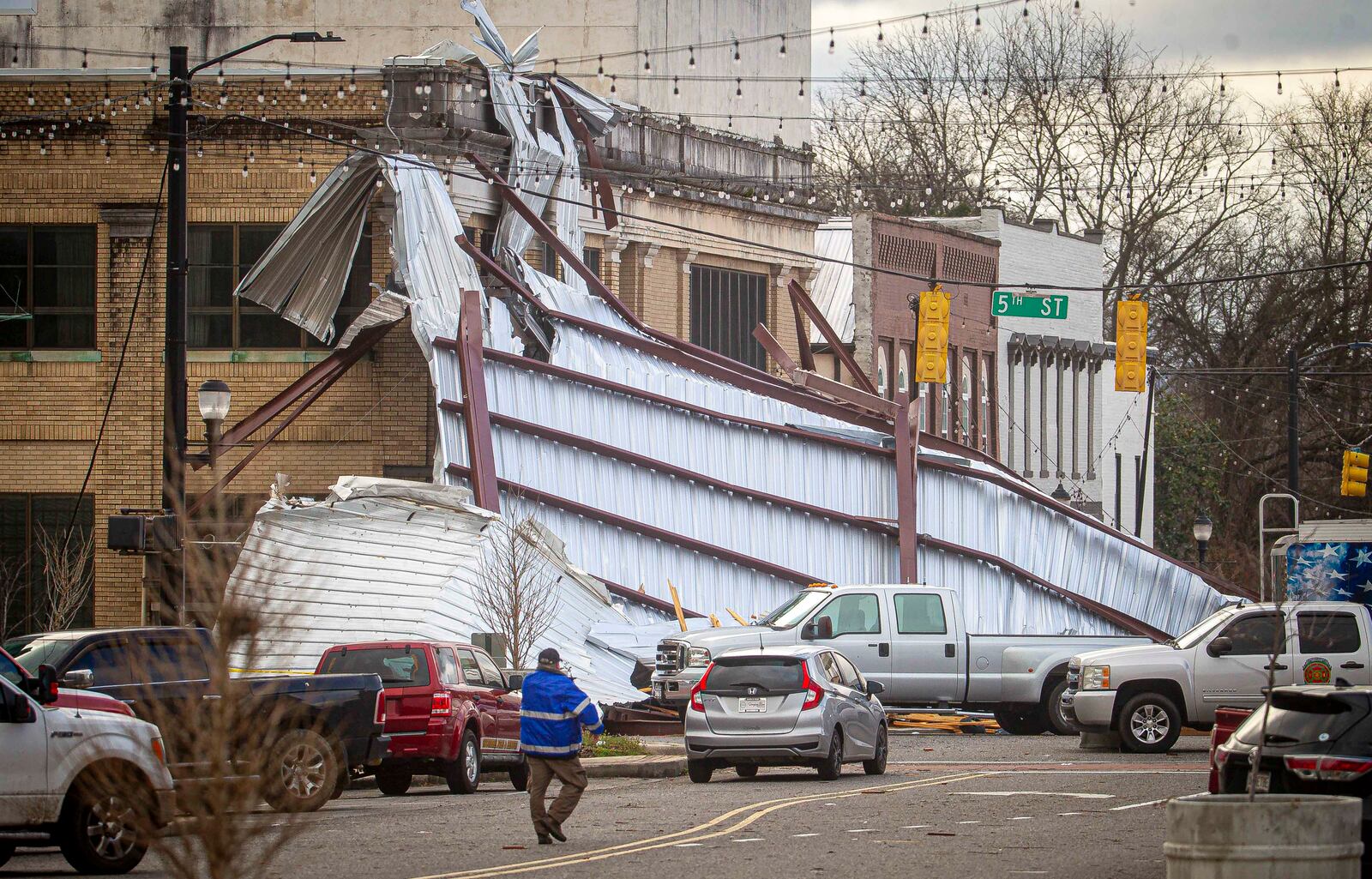 Roofing drapes over a building from a storm at the intersection of Main and Fifth Streets in downtown Tuscumbia, Ala., Sunday, Feb. 16, 2025. Dan Busey/The TimesDaily via AP)