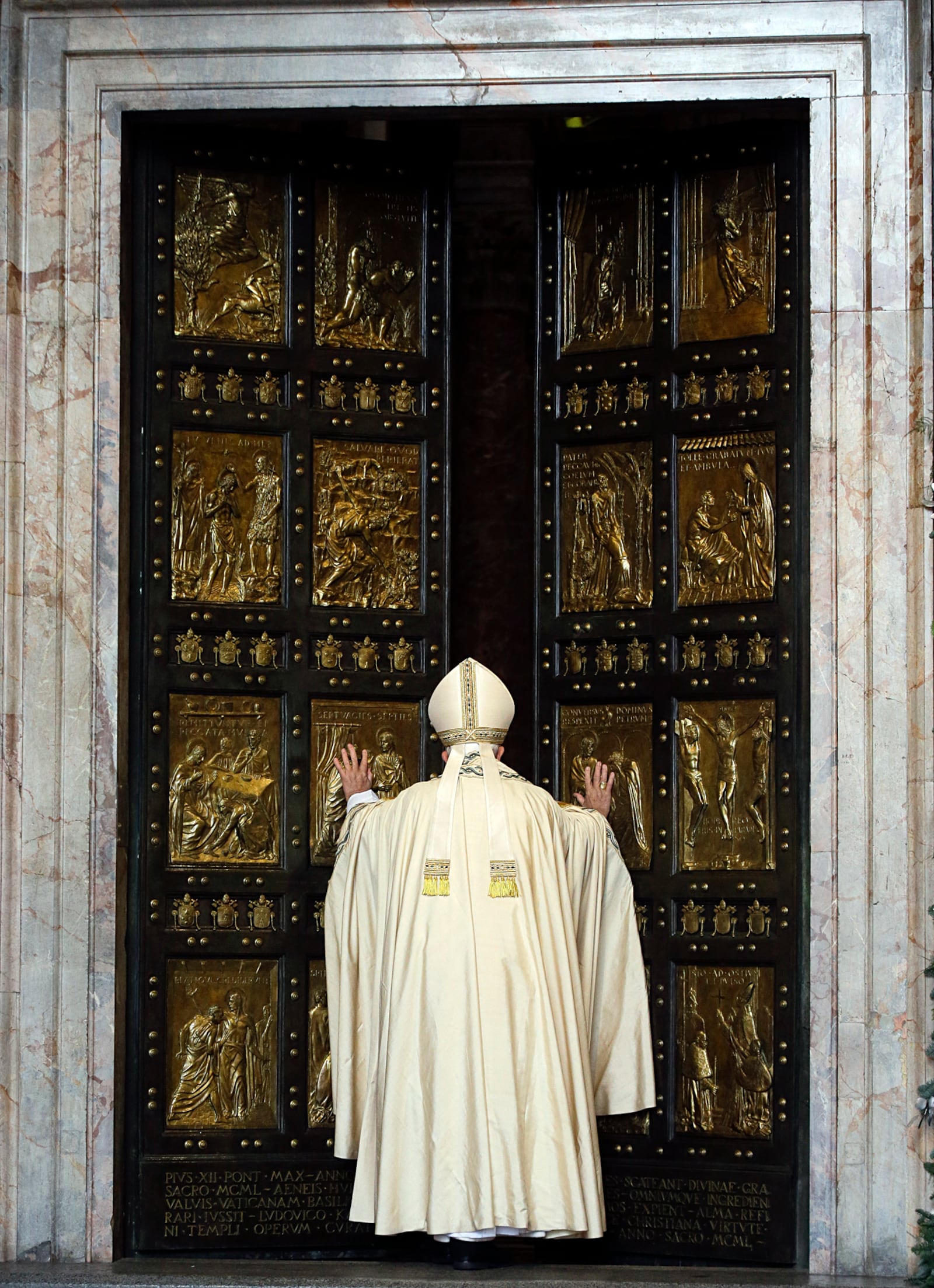 FILE - Pope Francis pushes open the Holy Door of St. Peter's Basilica, formally launching the Holy Year of Mercy, at the Vatican, Tuesday, Dec. 8, 2015. (AP Photo/Gregorio Borgia, File)