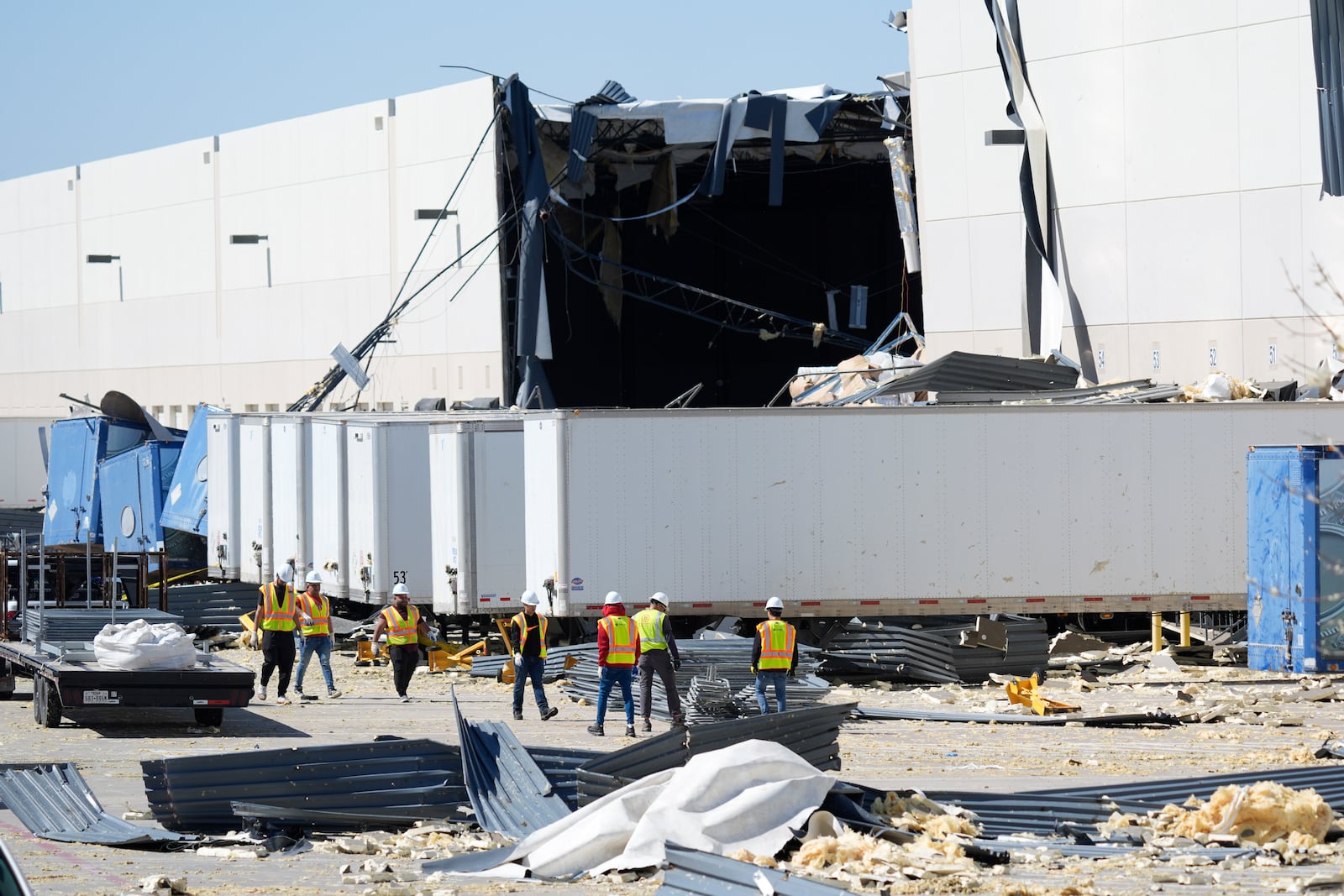 A workers walk outside a damaged warehouse after storms moved through Tuesday, March 4, 2025, in Lewisville, Texas. (AP Photo/LM Otero)