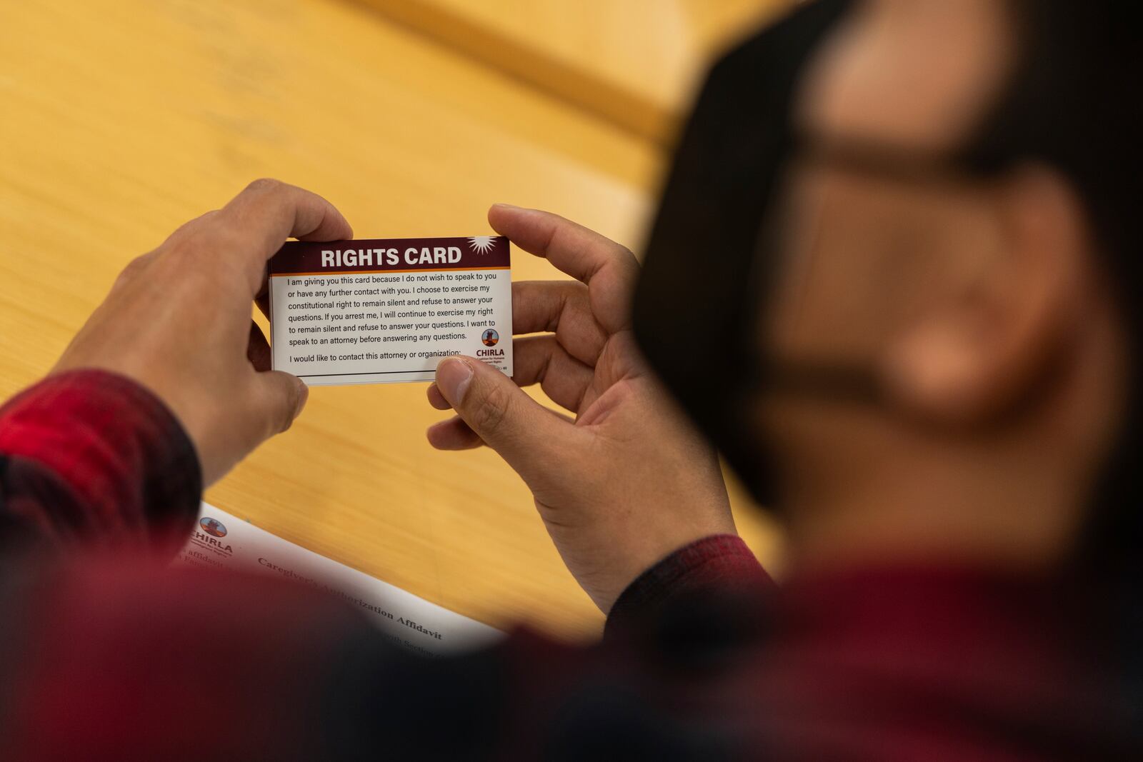 A participant holds a "rights card" during a bilingual workshop for immigrants who want to stay in the United States at the office of the Coalition for Humane Immigrant Rights organization in Los Angeles, Wednesday, Dec. 4, 2024. (AP Photo/Jae C. Hong)