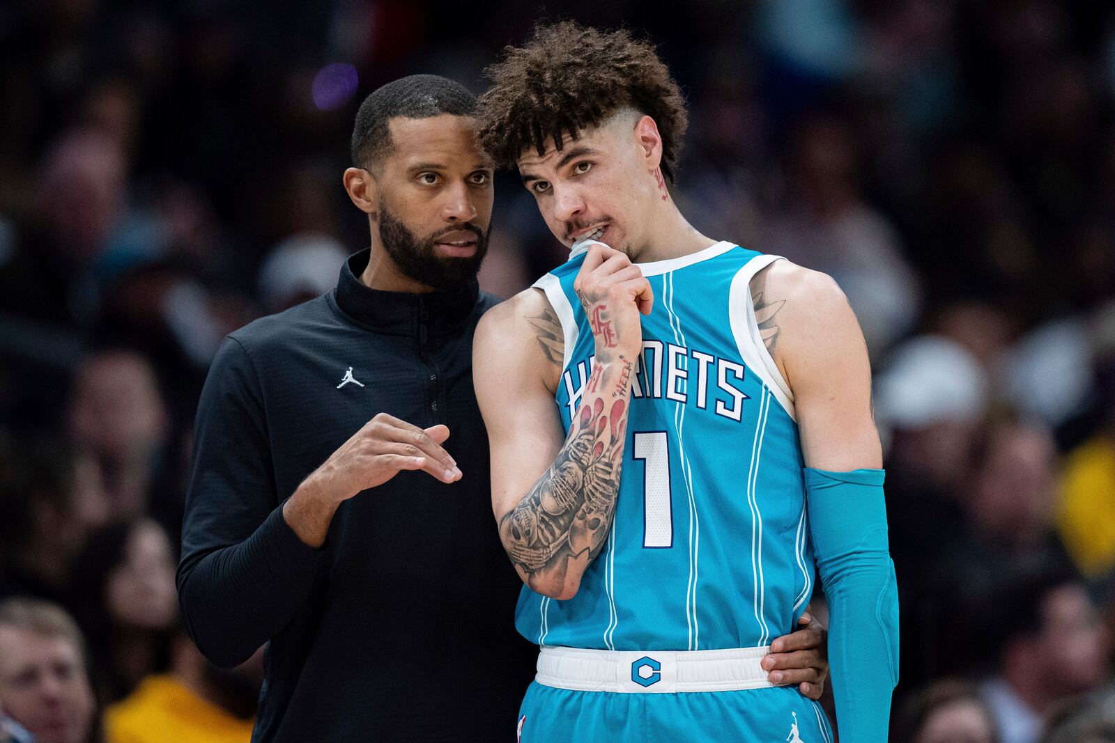 Charlotte Hornets head coach Charles Lee, left, talks with guard LaMelo Ball (1) during the first half of an NBA basketball game against the Los Angeles Lakers, Monday, Jan. 27, 2025, in Charlotte, N.C. (AP Photo/Jacob Kupferman)