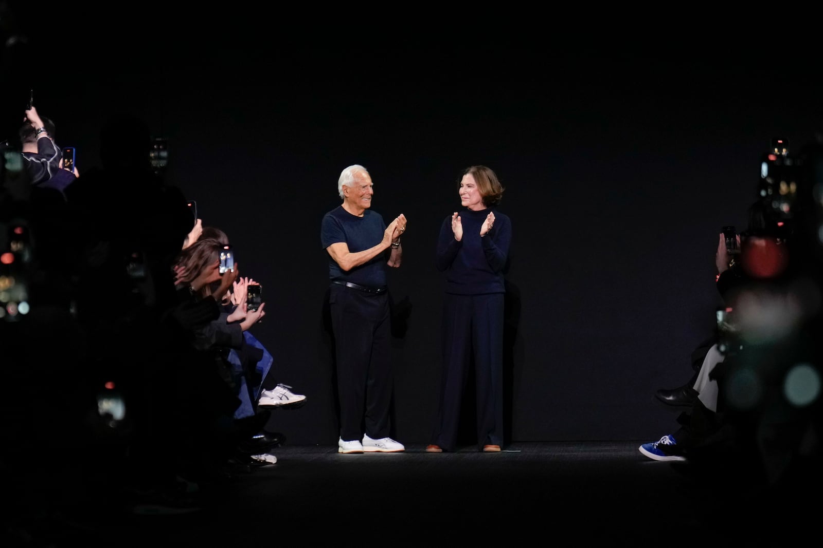 Designer Giorgio Armani, left, and Silvana Armani accept applause after the Emporio Armani Fall/Winter 2025-2026 Womenswear collection presented in Milan, Italy, Thursday, Feb. 27, 2025. (AP Photo/Luca Bruno)