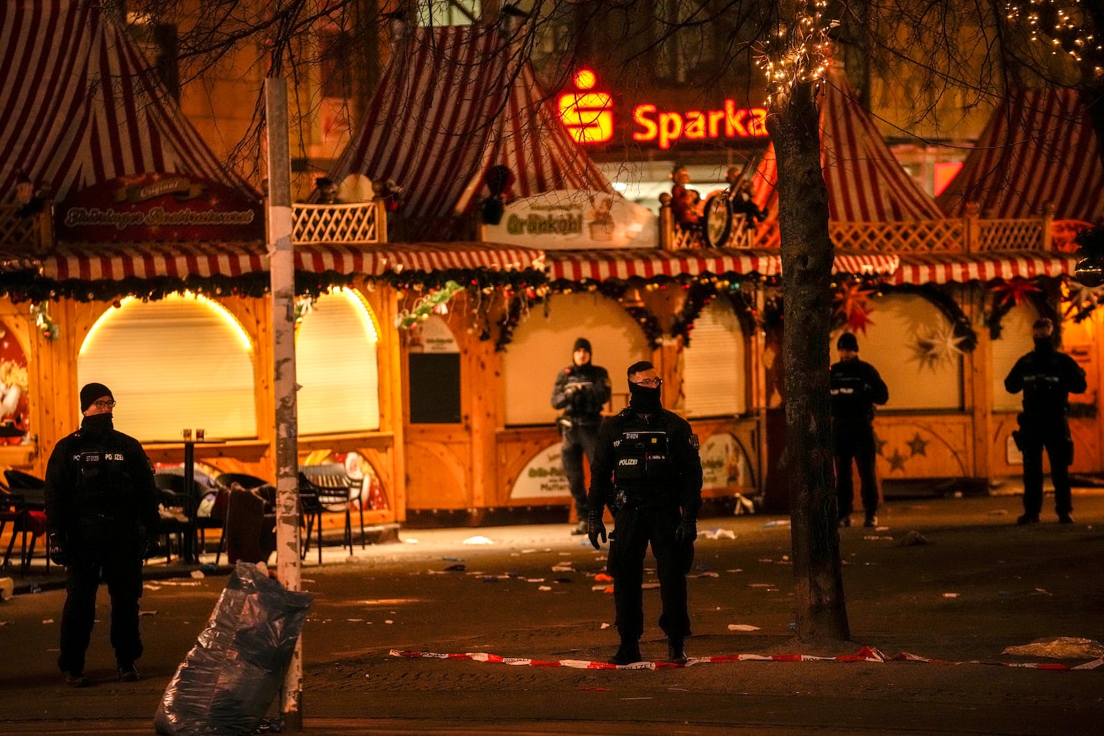 Security guards stand in front of a cordoned-off Christmas Market after a car crashed into a crowd of people, in Magdeburg, Germany, Saturday early morning, Dec. 21, 2024. (AP Photo/Ebrahim Noroozi)