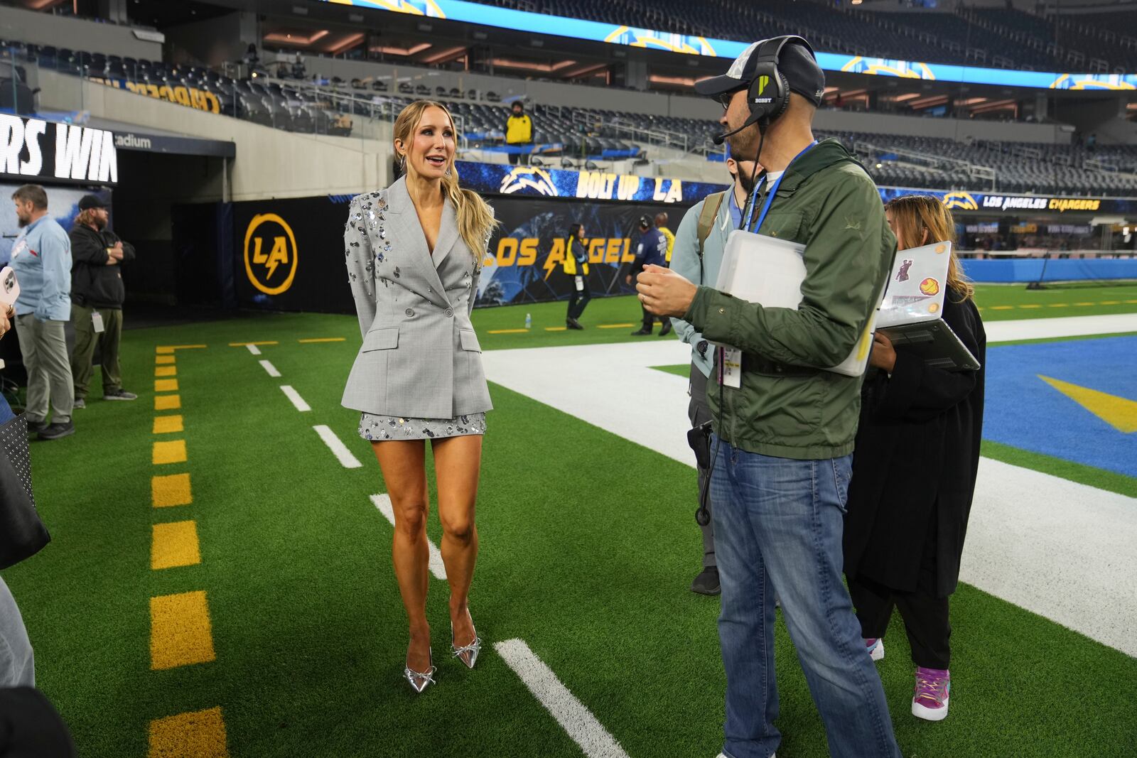 Nikki Glaser stands on the field after NFL football game between the Los Angeles Chargers and the Denver Broncos, Thursday, Dec. 19, 2024, in Inglewood, Calif. (AP Photo/Eric Thayer)