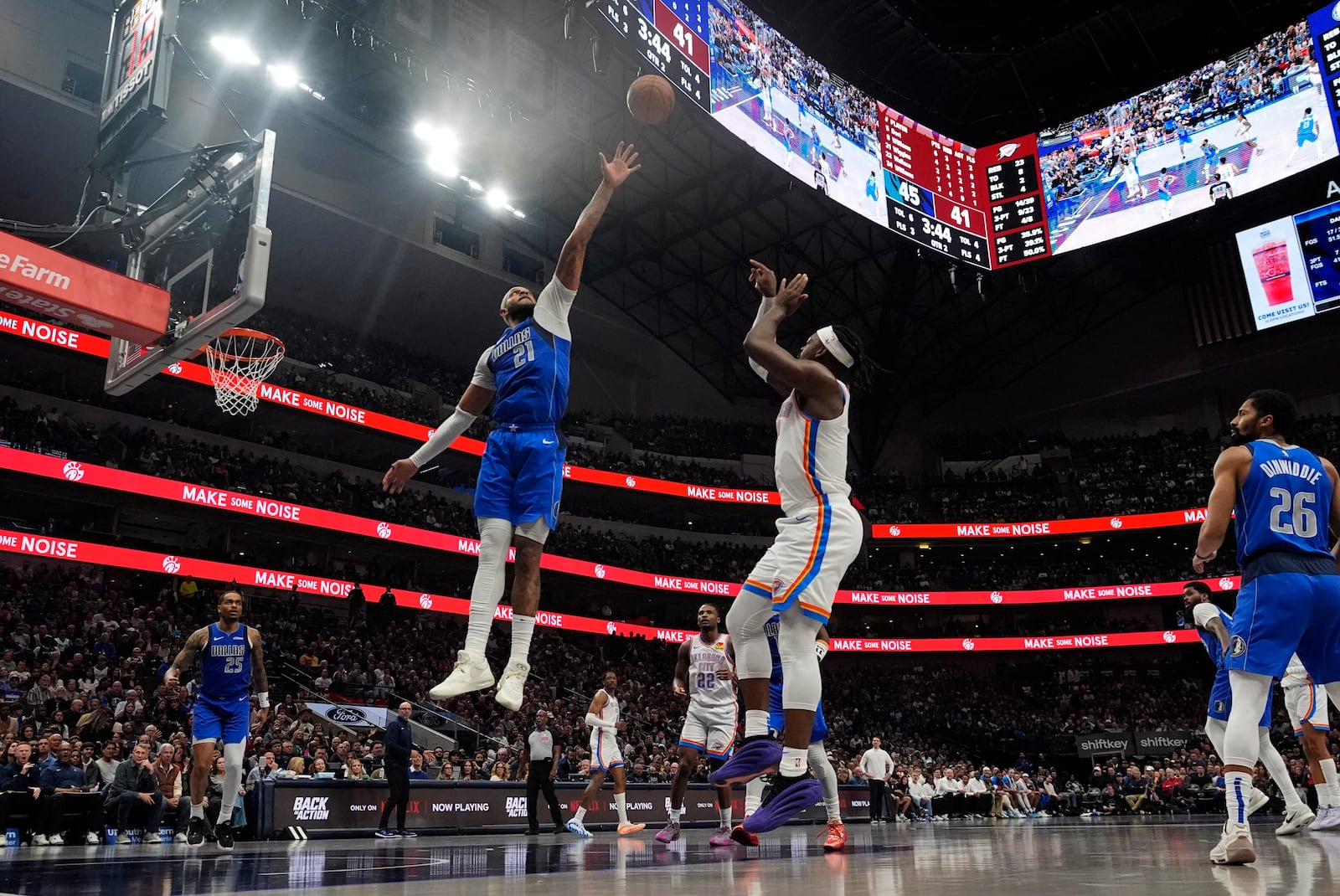 Dallas Mavericks center Daniel Gafford (21) defends against a shot by Oklahoma City Thunder guard Luguentz Dort, center right, during the first half of an NBA basketball game Friday, Jan. 17, 2025, in Dallas. (AP Photo/LM Otero)