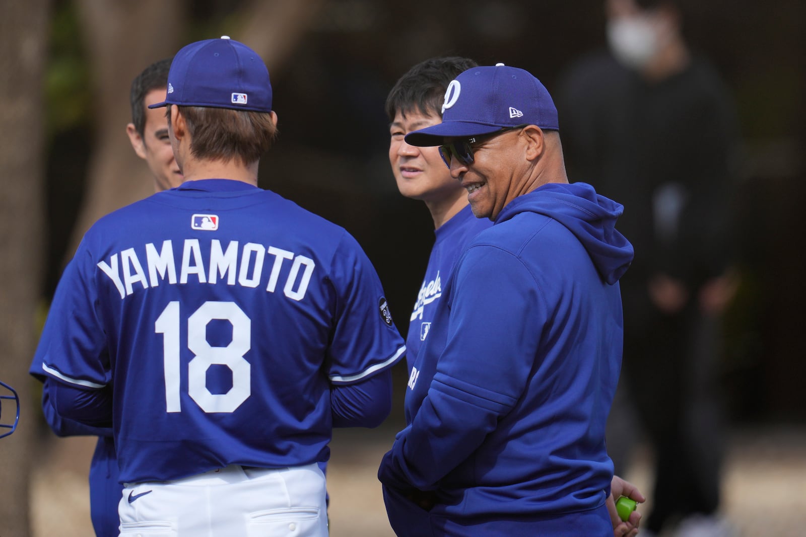 Los Angeles Dodgers pitcher Yoshinobu Yamamoto (18), of Japan, gets a smile out of Dodgers manager Dave Roberts, right, after Yamamoto's pitching session at the Dodgers baseball spring training facility Tuesday, Feb. 11, 2025, in Phoenix. (AP Photo/Ross D. Franklin)