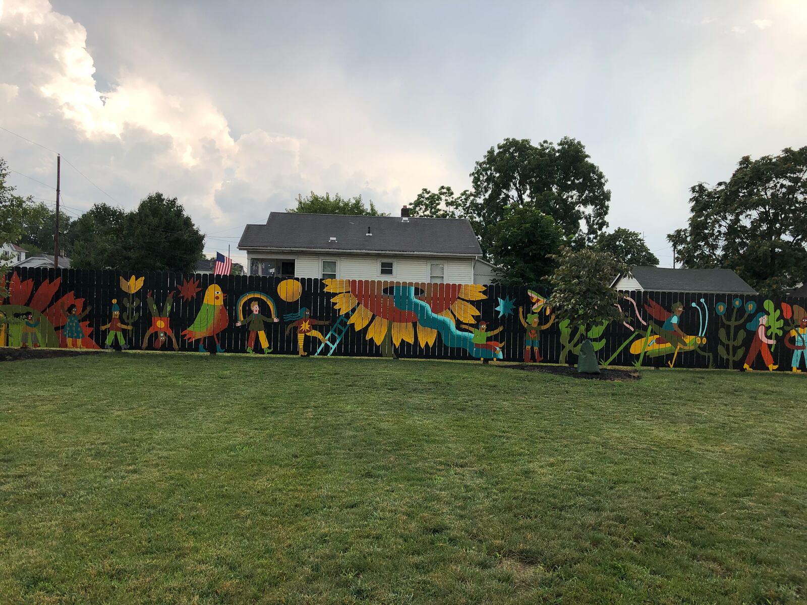 Residents of the Jefferson neighborhood gathered Tuesday to dedicate the new mural, Garden Parade, in the two-year-old Jefferson Park. MIKE RUTLEDGE/STAFF