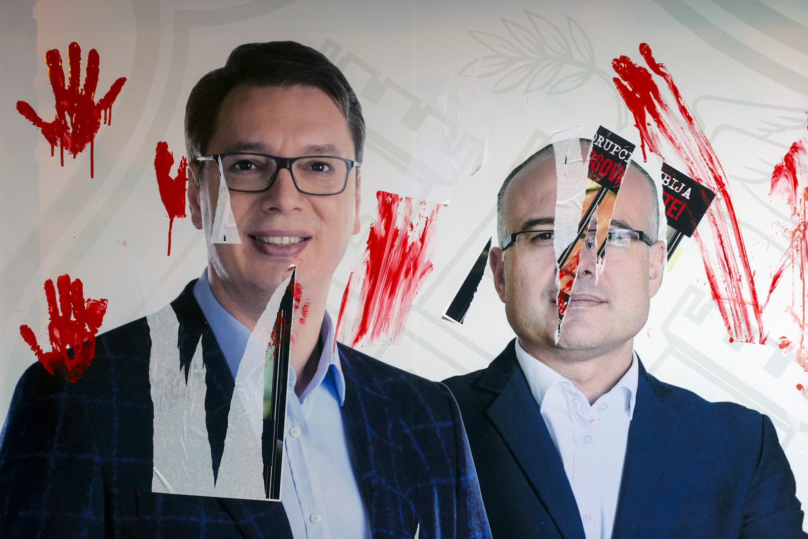 A photo of Serbia's president Aleksandar Vucic, left, and the country's prime minister Milos Vucevic is smeared with red paint during a protest in Novi Sad, Serbia, Tuesday, Nov. 5, 2024. (AP Photo/Marko Drobnjakovic)