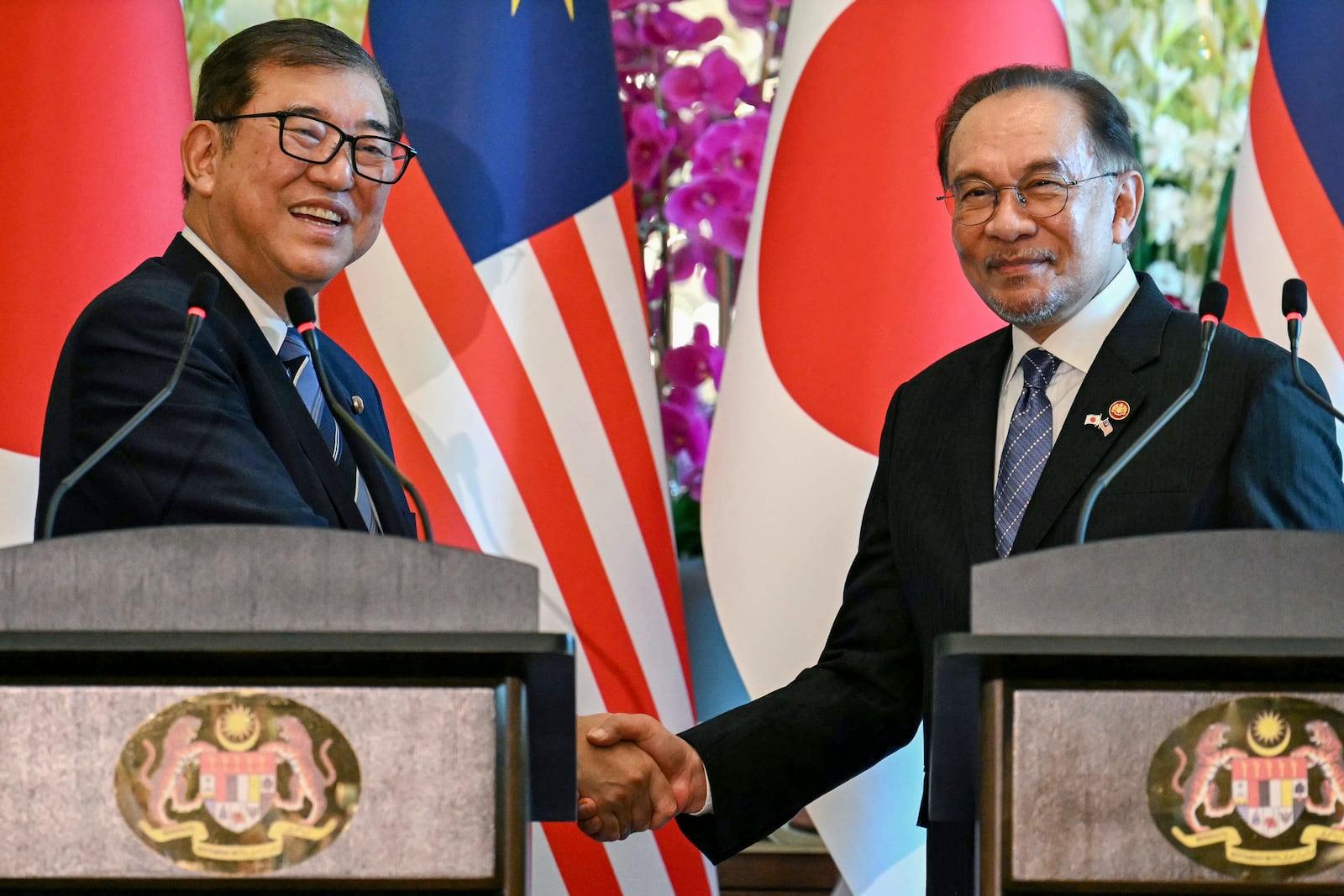 Malaysia's Prime Minister Anwar Ibrahim, right, and Japan's Prime Minister Shigeru Ishiba shake hands during a joint press conference at the prime minister's office in Putrajaya, Malaysia, Friday, Jan. 10, 2025. (Mohd Rasfan/Pool Photo via AP)