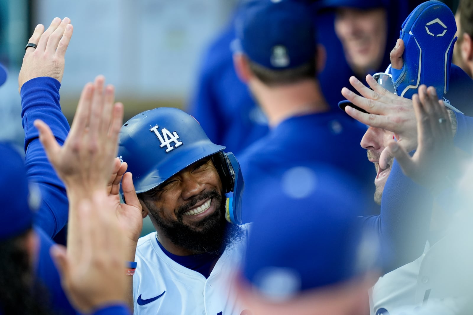 Los Angeles Dodgers' Teoscar Hernández celebrates in the dugout after scoring on a double by Tommy Edman against the New York Mets during the first inning in Game 6 of a baseball NL Championship Series, Sunday, Oct. 20, 2024, in Los Angeles. (AP Photo/Ashley Landis)