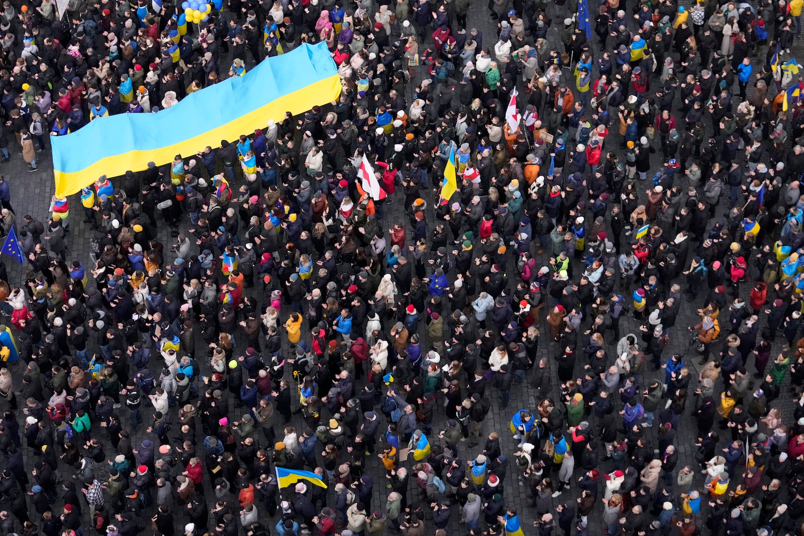 People hold a large Ukrainian flag as thousands gather to mark three years since the start of Russia's invasion of Ukraine in Prague, Czech Republic, Sunday, Feb. 23, 2025. (AP Photo/Petr David Josek)