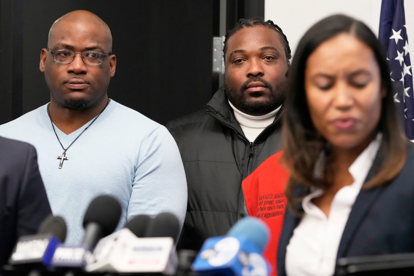 Sexual assault survivors Marcus Walker, left, and Charles Graves, center, listen to attorney Kristen Feden's speech during a news conference in Chicago, Tuesday, Feb. 11, 2025. (AP Photo/Nam Y. Huh)