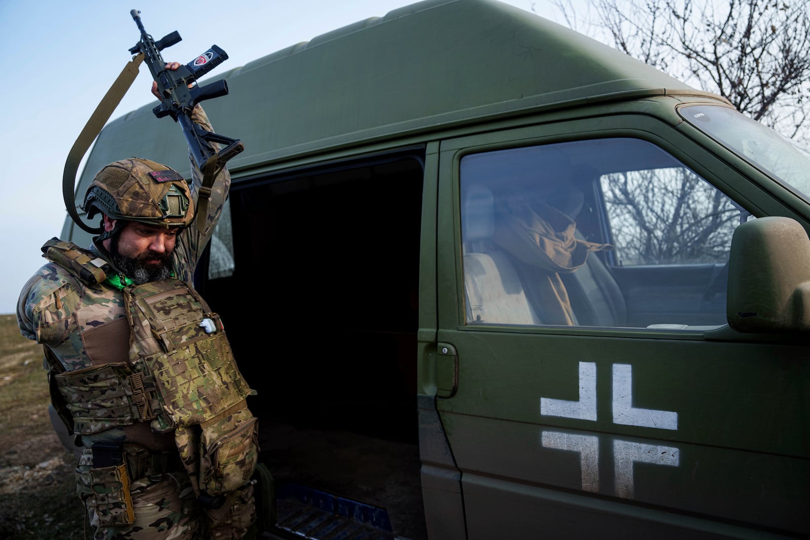 Ukrainian soldier Oleksandr Zhalinskyi of the Azov brigade, who serves as a navigator for evacuation missions after losing his right arm in battle, holds up a rifle in Ukraine's Donetsk region on Jan. 31, 2025. (AP Photo/Evgeniy Maloletka)