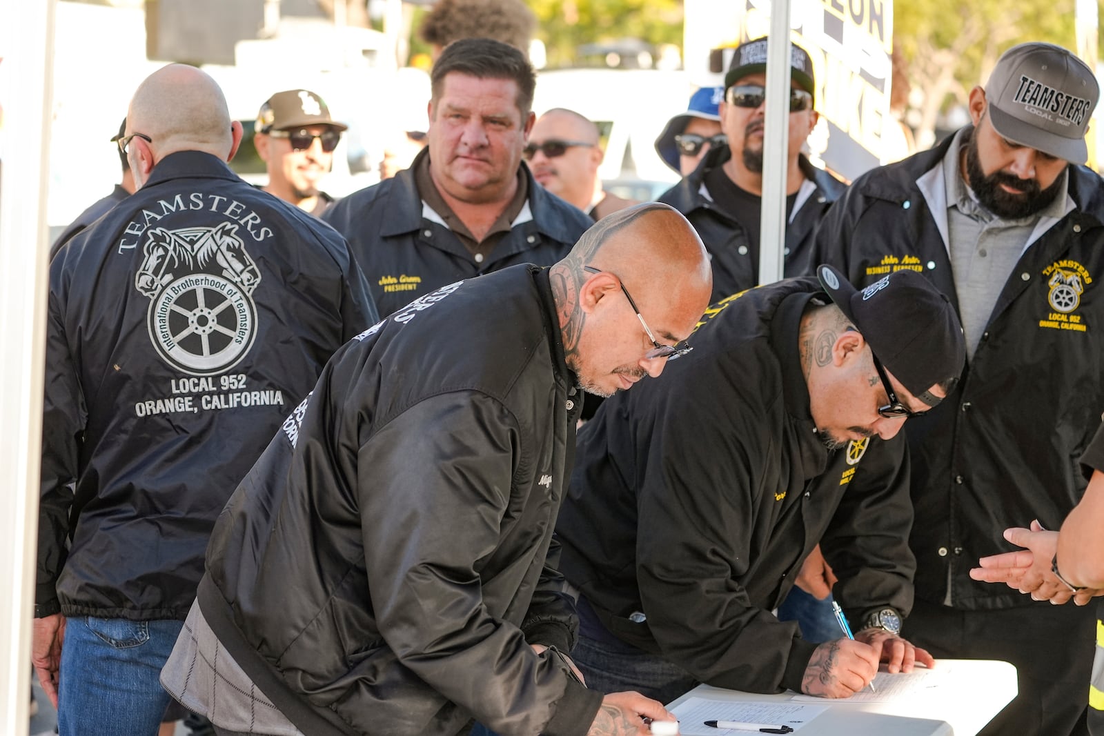 Teamsters Local 952 members sign-in as they join Amazon workers striking outside the gates of an Amazon Fulfillment Center, Thursday, Dec. 19, 2024, in City of Industry, Calif. (AP Photo/Damian Dovarganes)