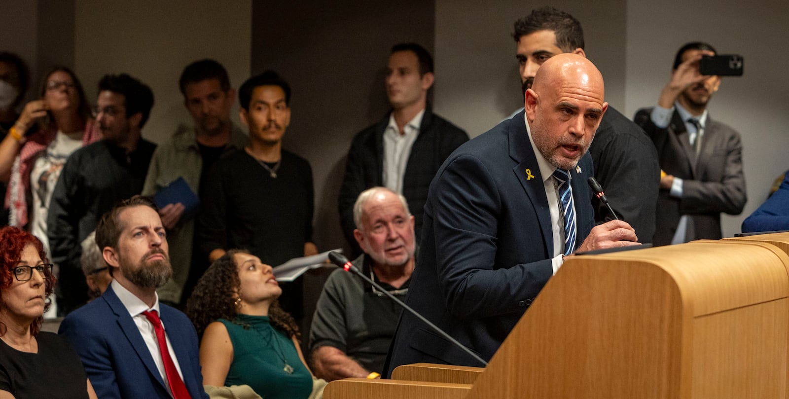 Israel's Council General in Miami, Maor Elbaz-Starinski, peaks in support of Mayor Steven Miner during an extended public speaking portion as the City Commission was expected to discuss Meiner's proposal to terminate a lease and cut financial support for O Cinema, the independent film theater on Wednesday, March 19, 2025 in Miami Beach, Fla. (Jose Iglesias /Miami Herald via AP)