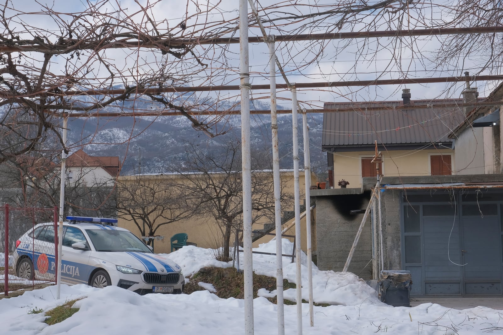 A view of a police vehicle at the home of a gunman after a shooting incident, in Cetinje, 36 kilometers (22 miles) west of Podogrica, Montenegro, Thursday, Jan. 2, 2025. (AP Photo/Risto Bozovic)