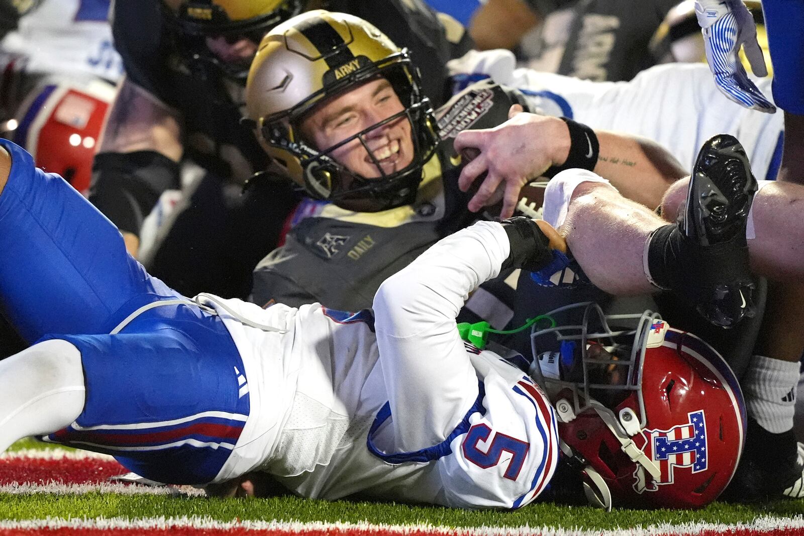 Army quarterback Bryson Daily (13) smiles as he scores a touchdown past Louisiana Tech defensive back Michael Richard (5) during the second half of the Independence Bowl NCAA college football game, Saturday, Dec. 28, 2024, in Shreveport, La. (AP Photo/Rogelio V. Solis)