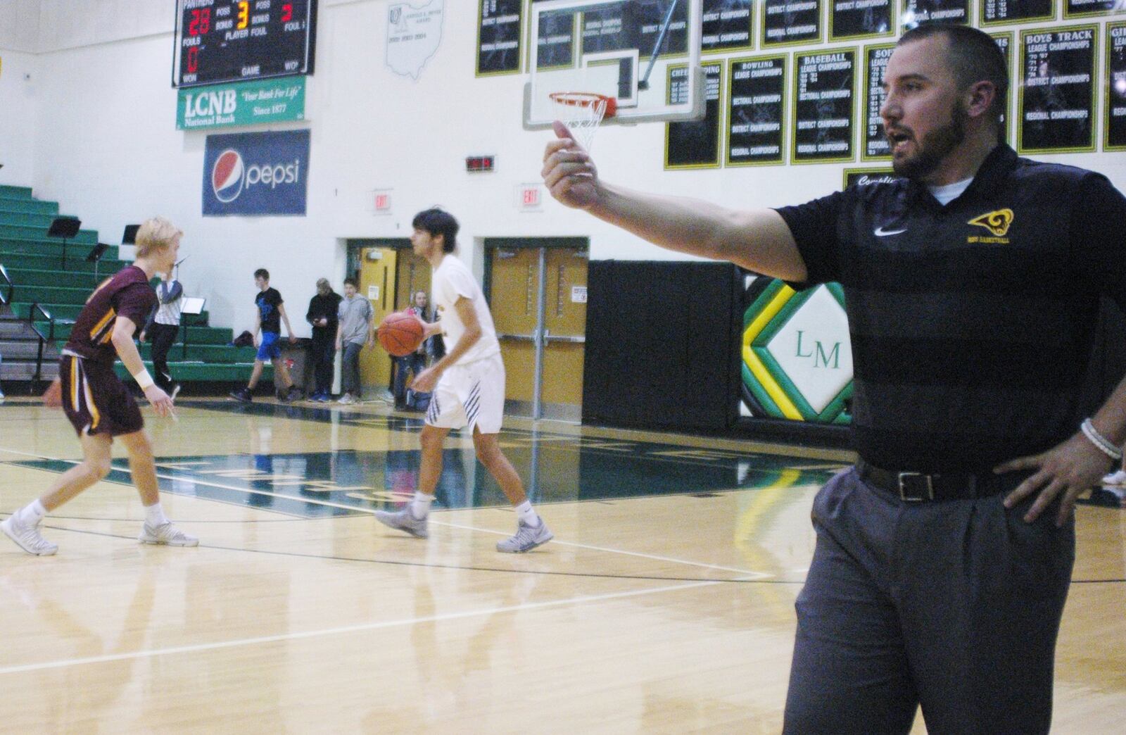 Ross coach David Lane makes a call as the Rams’ Dylan Zimmerman guards Little Miami’s Ketan Prathapa coming up the floor Friday night at Little Miami. The host Panthers won 52-51. RICK CASSANO/STAFF