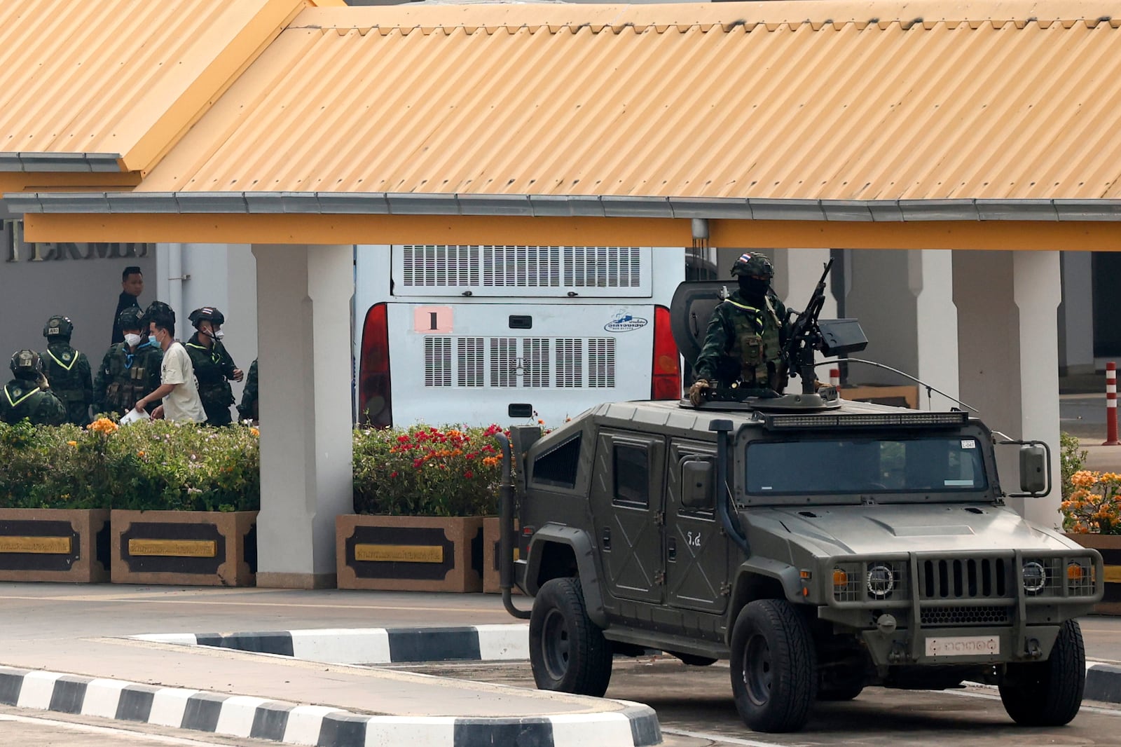 Thai soldiers provide security for the transfer of Chinese nationals who had worked at scam centers in eastern Myanmar, on their arrival at Thailand's Mae Sot International Airport, Tak province before being sent back to China on Thursday, Feb. 20, 2025. (AP Photo/Sarot Meksophawannakul)