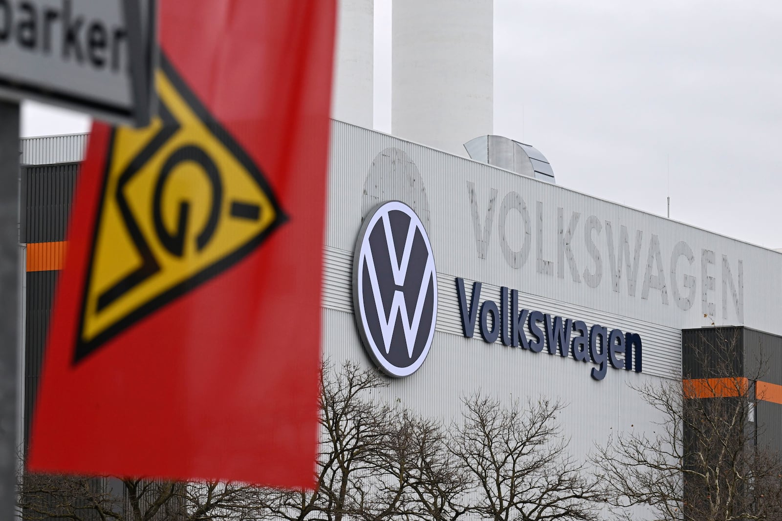 An IG Metall trade union flag flies at the gate of a Volkswagen plant on the first day of a nationwide Volkswagen workers' strike, in Zwickau, Germany, Monday, Dec. 2, 2024. (Hendrik Schmidt/dpa via AP)