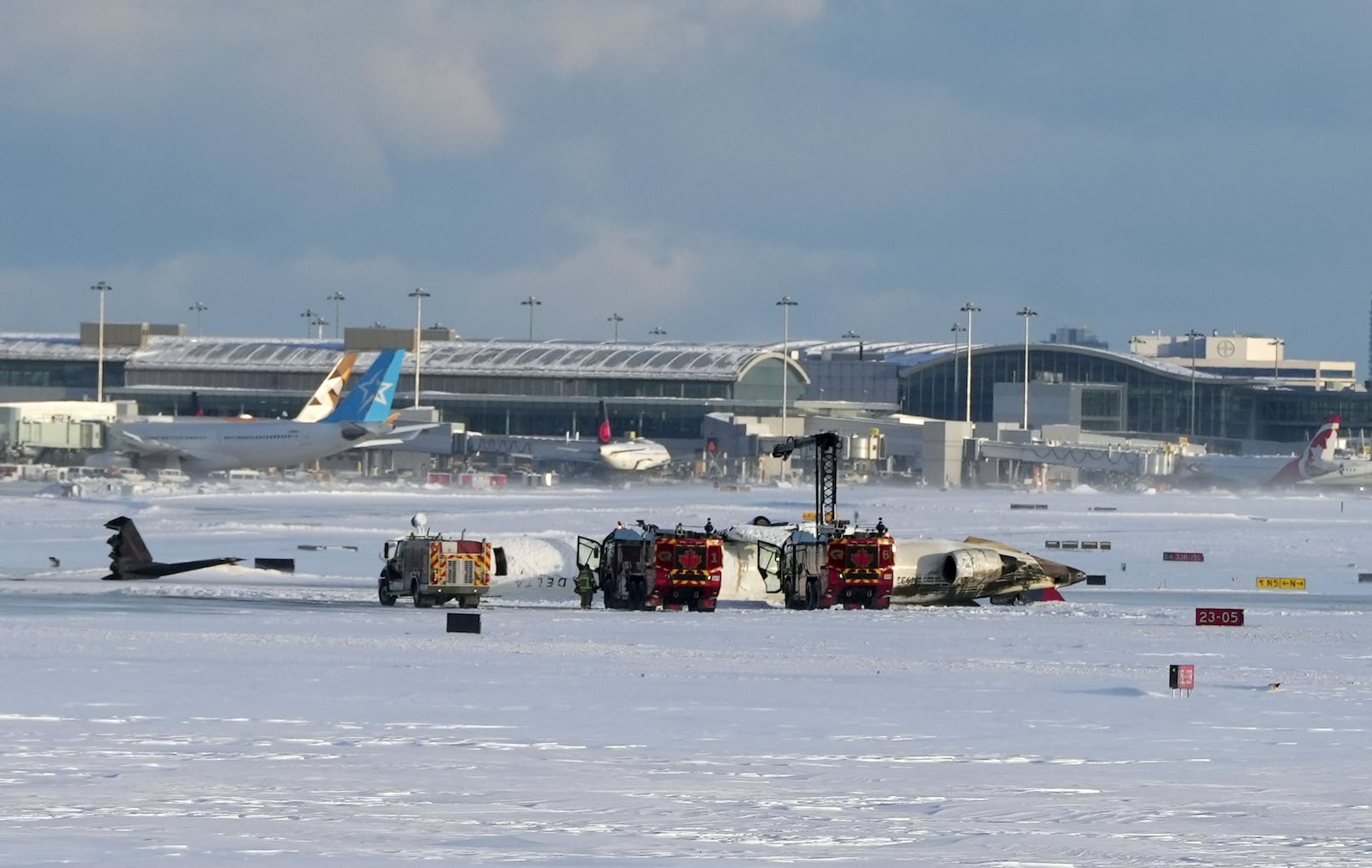 An aircraft from Delta Airlines sits upside down on the tarmac in snow at Toronto Pearson International airport, Monday Feb. 17, 2025. (Teresa Barbieri/The Canadian Press via AP)