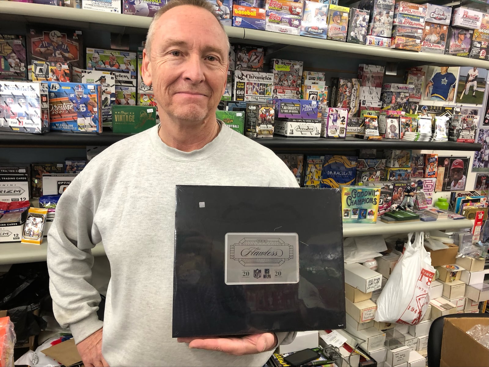 Kevin Ashcraft, owner of Hooterville Sports Cards in Fairfield, says he sells boxes of 2020 Flawless for $12,000 to customers who are trying to get a rare autographed football card. RICK McCRABB/STAFF