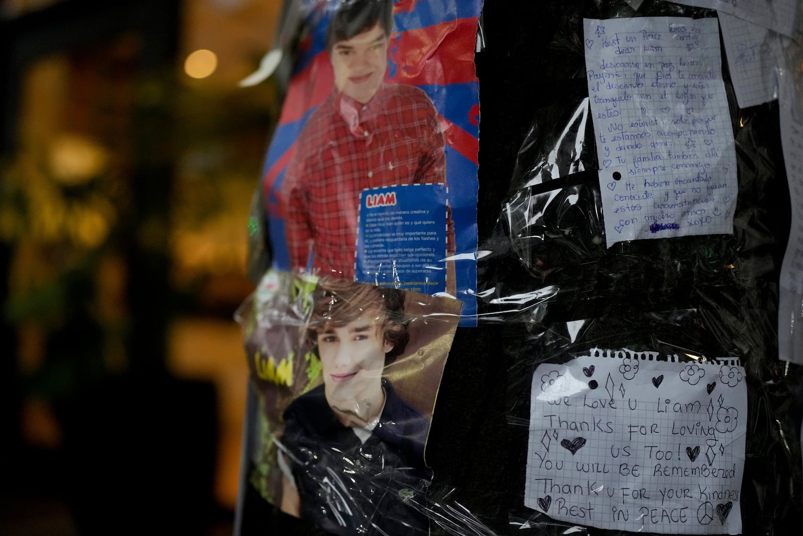 Photos of former One Direction singer Liam Payne and messages from fans are taped to a tree outside the hotel where he was found dead after falling from a balcony in Buenos Aires, Argentina, the morning after the incident, Thursday, Oct. 17, 2024. (AP Photo/Natacha Pisarenko)